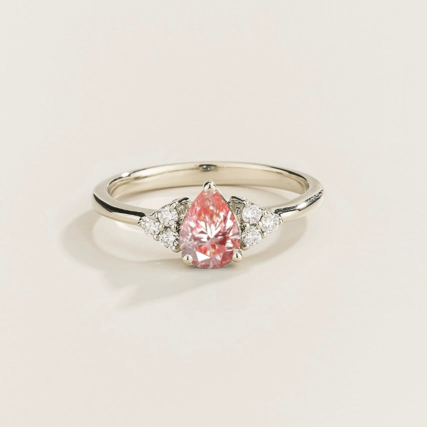 Juvetti white gold ring featuring a pear-cut lab-grown padparadscha sapphire with lab-grown diamond side stones.