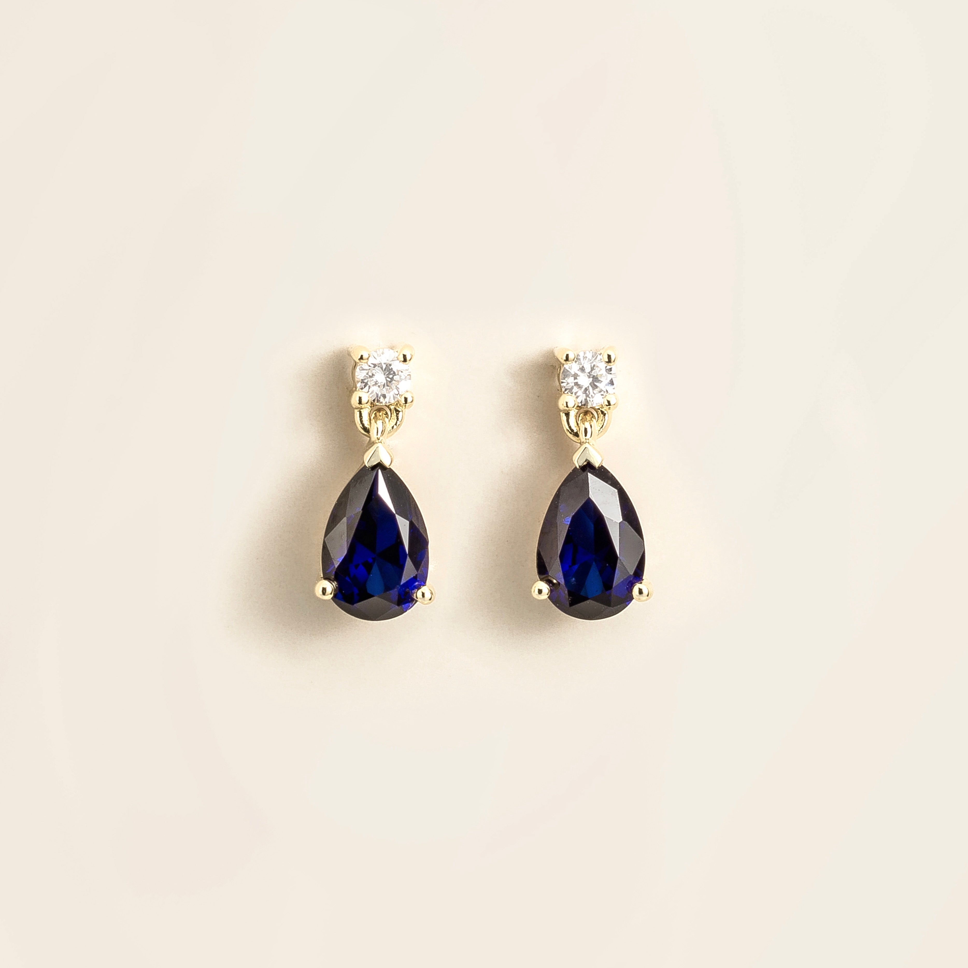 Juvetti white gold earrings featuring pear-cut lab-grown blue sapphires with diamond studs.