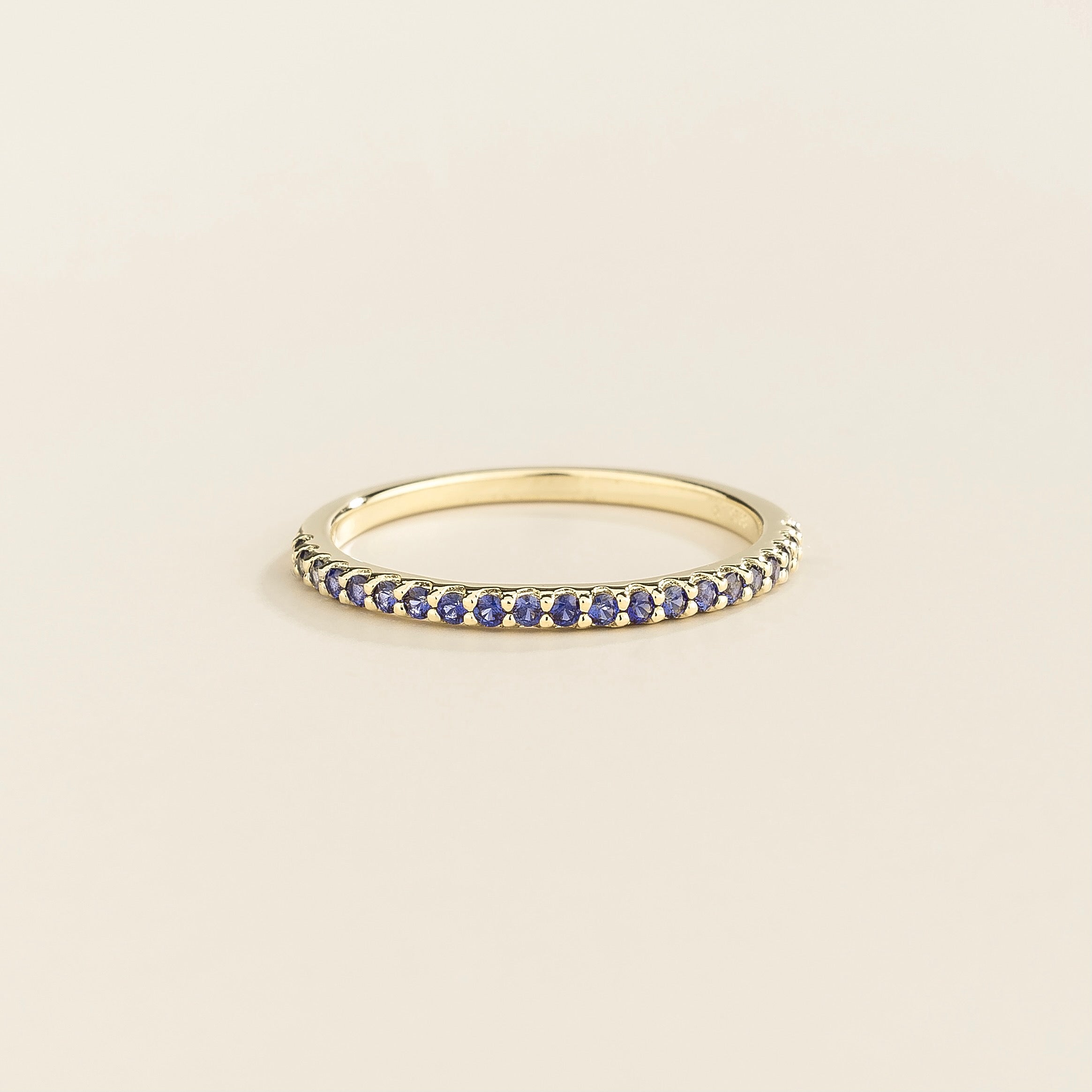 Juvetti white gold half eternity band set with round lab-grown blue sapphire gemstones.