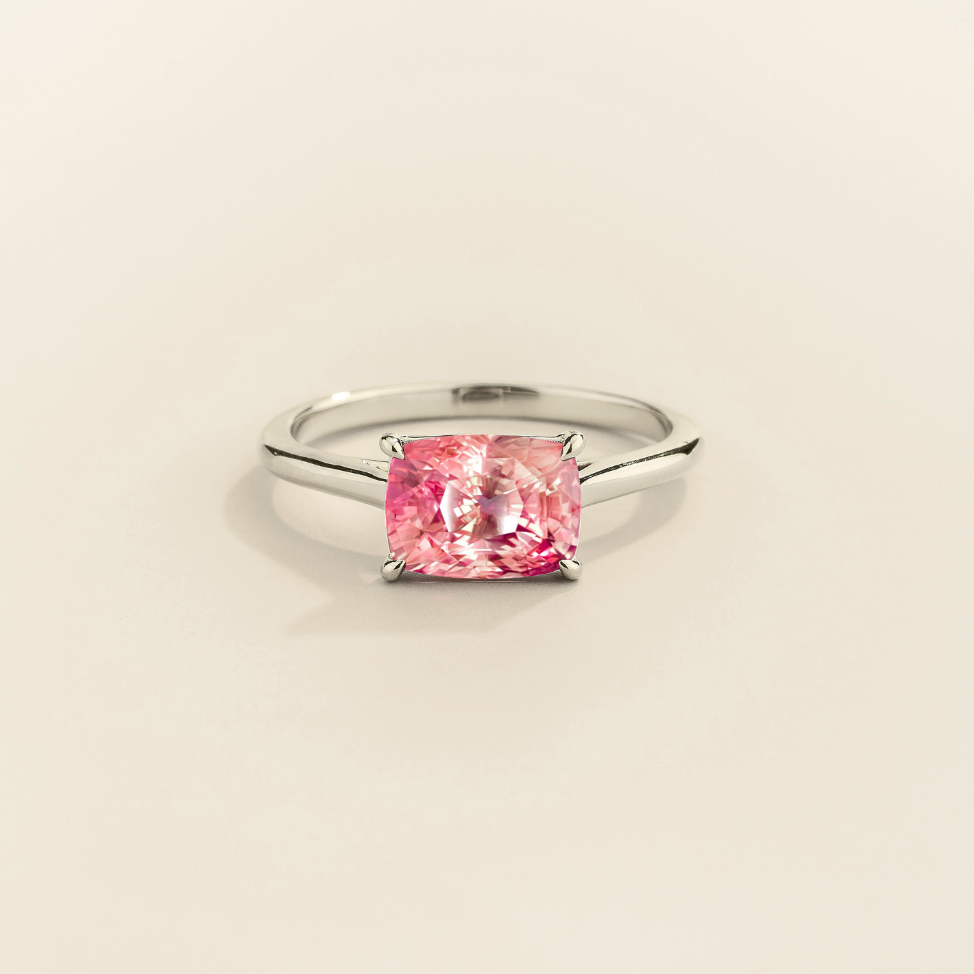 Kissen Ring in white gold, set with Padparadscha Sapphire in an east–west setting.