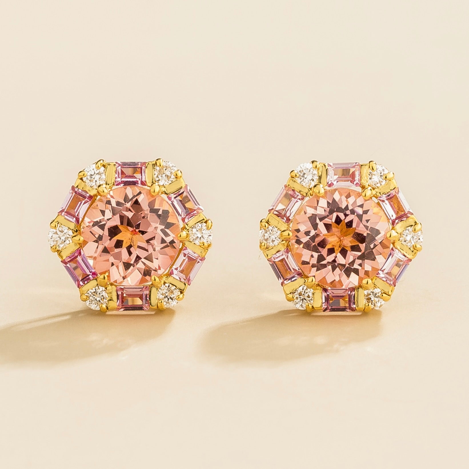 A pair of hexagon gold earrings set with round Padparadscha sapphires, baguette Pink sapphires and round Diamonds.