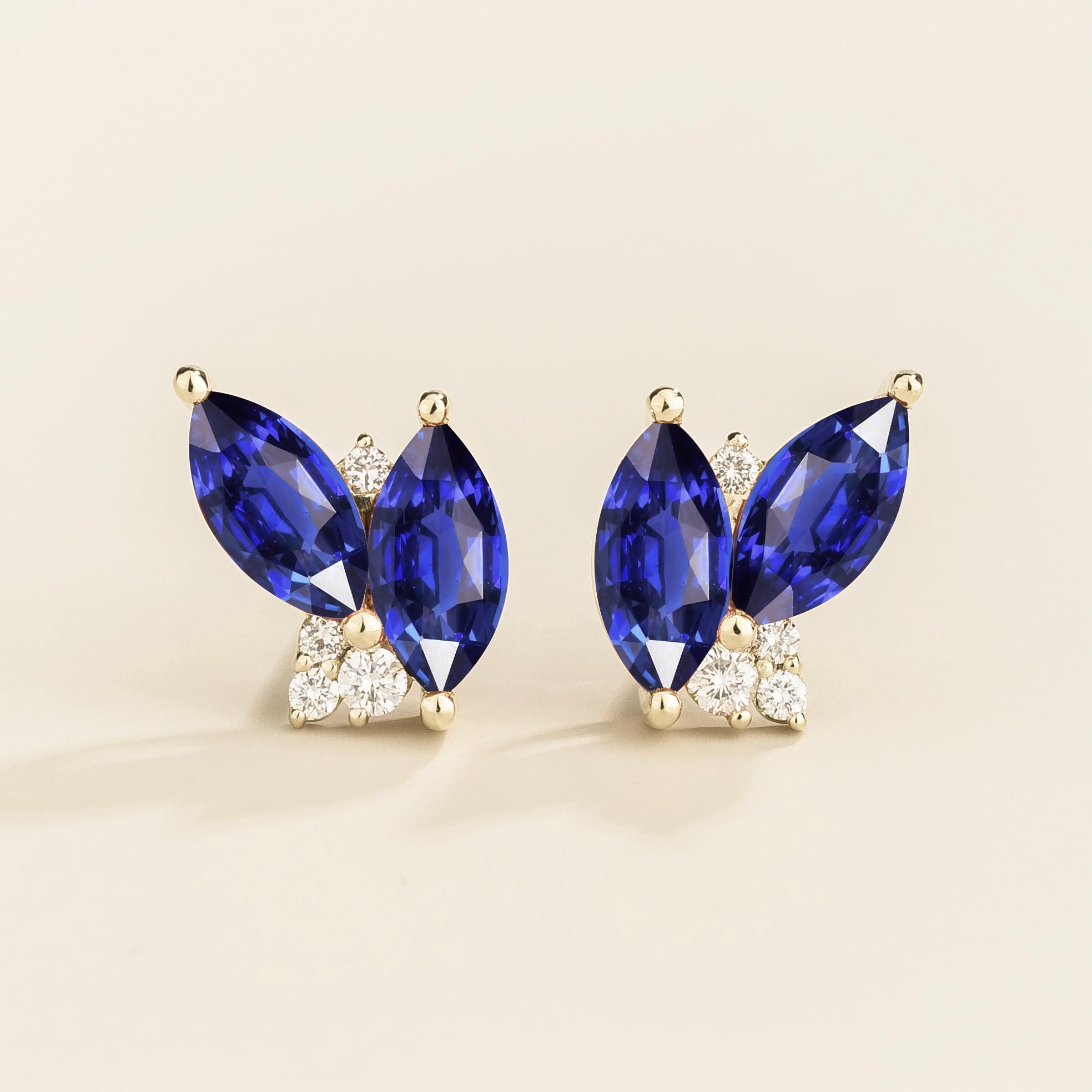 A pair of white gold earrings with marquise cut blue sapphires with by smaller round diamonds. London jewellery store