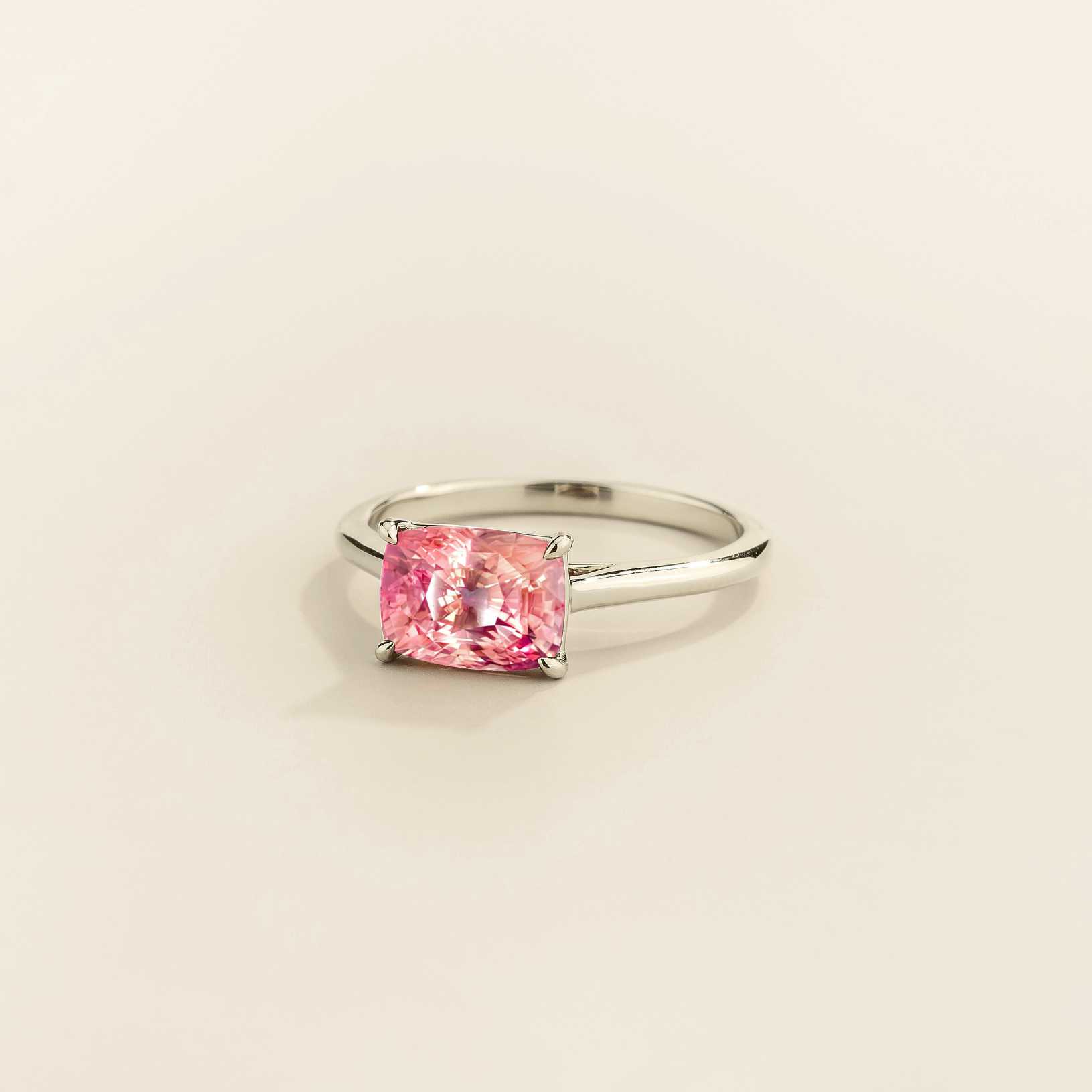 Kissen Ring in white gold, set with Padparadscha Sapphire in an east–west setting.