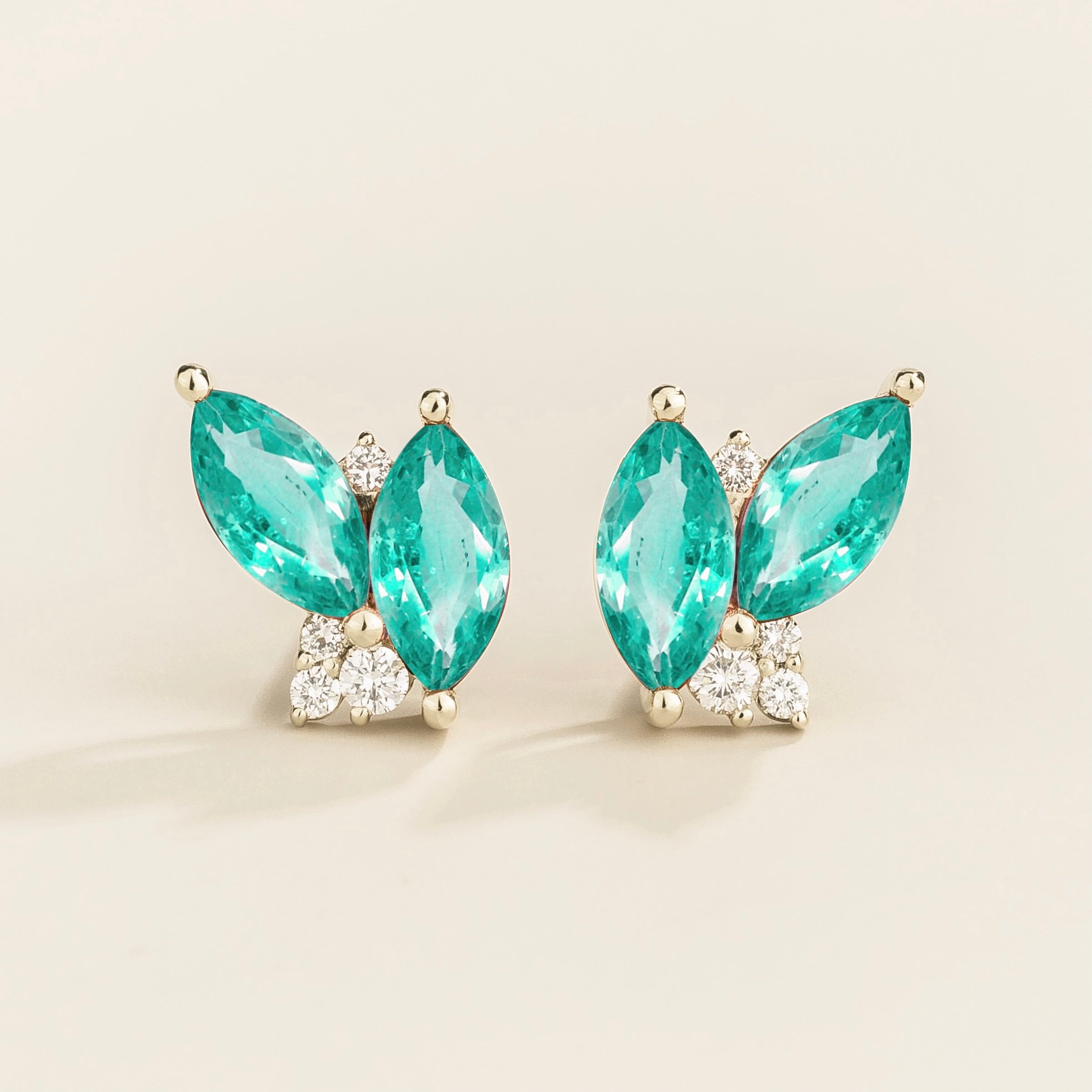 A pair of white gold earrings with marquis shaped paraiba sapphires and round diamonds.
