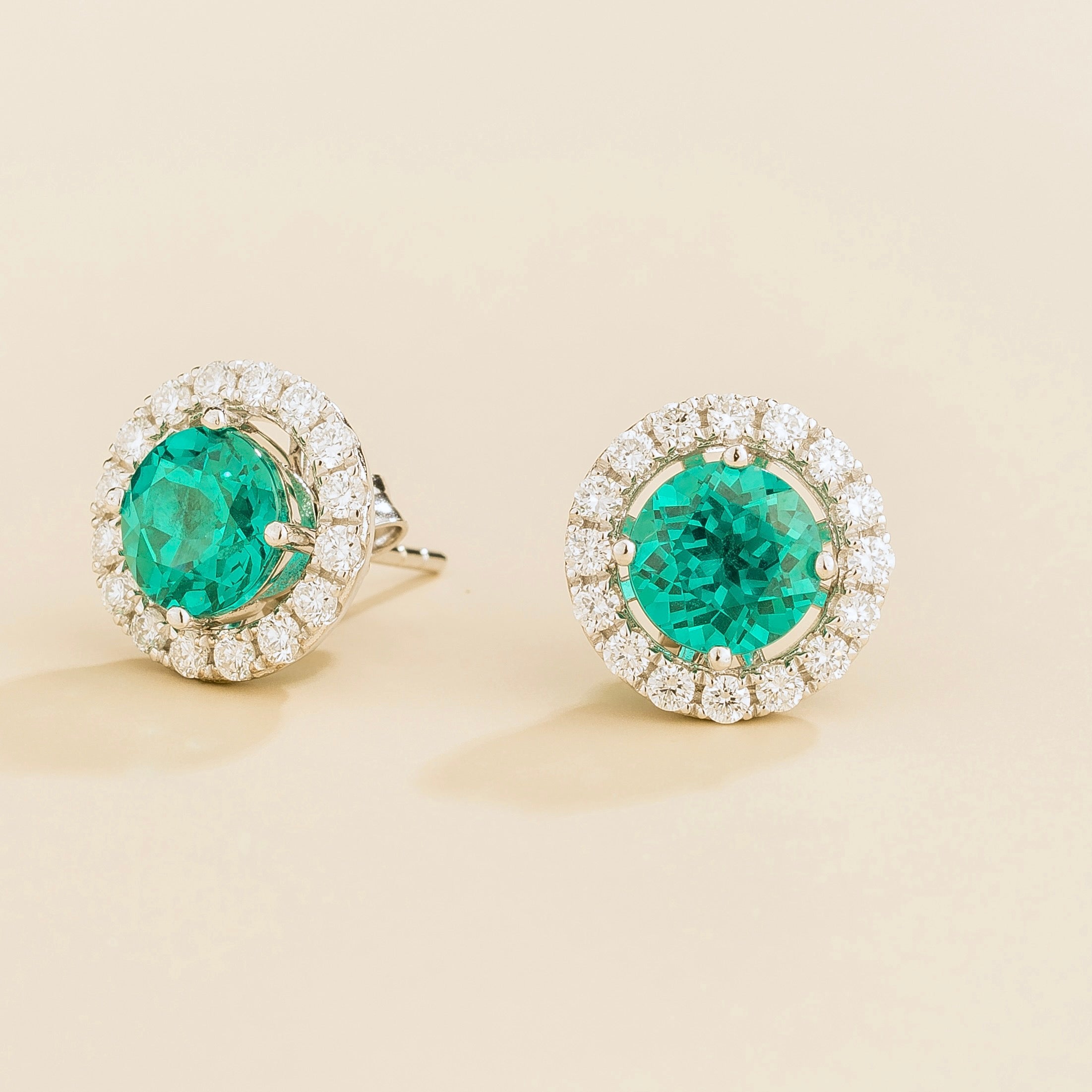 A pair of white gold floret earrings set with round paraiba sapphire centerpiece and surrounding round diamonds halo. Removable halo piece. – Juvetti London