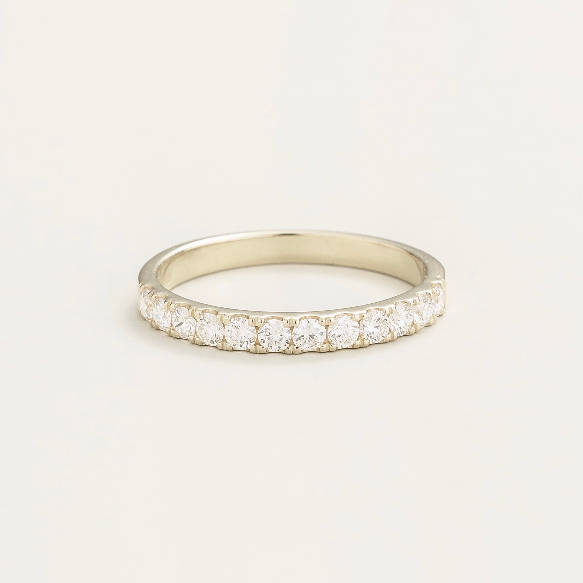 A white gold half eternity ring with a band of round-cut diamonds set close together.