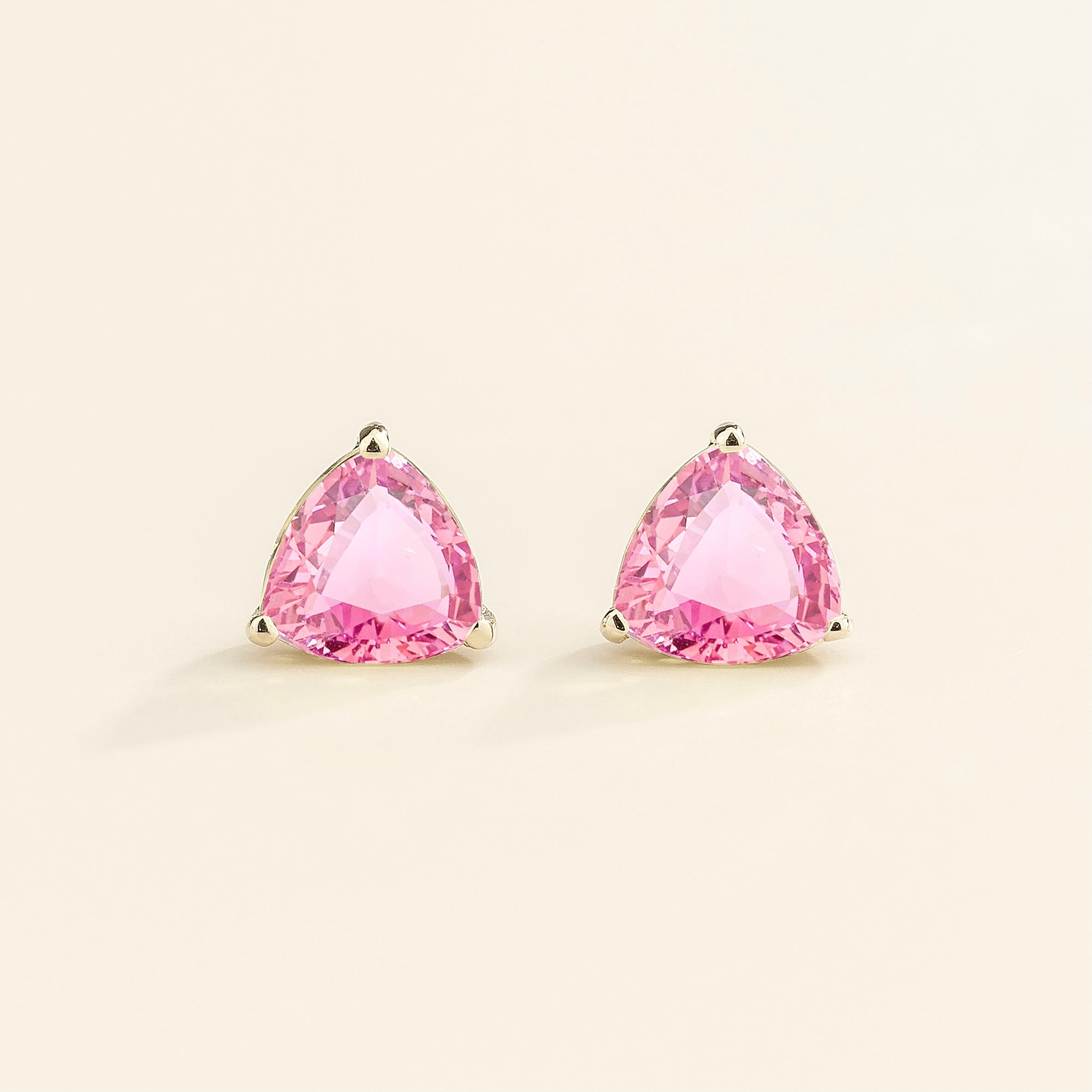 A pair of white gold trillion earrings set with pink sapphires.