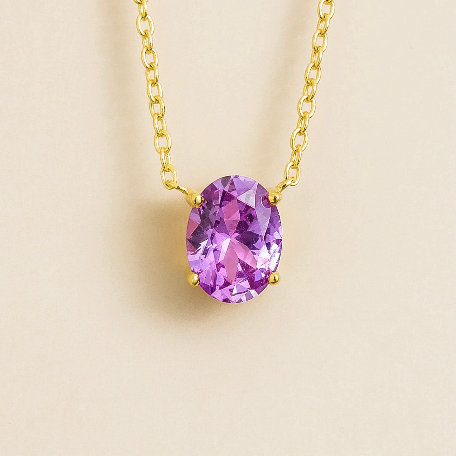 Juvetti gold necklace featuring an oval lab-grown purple sapphire solitaire pendant.
