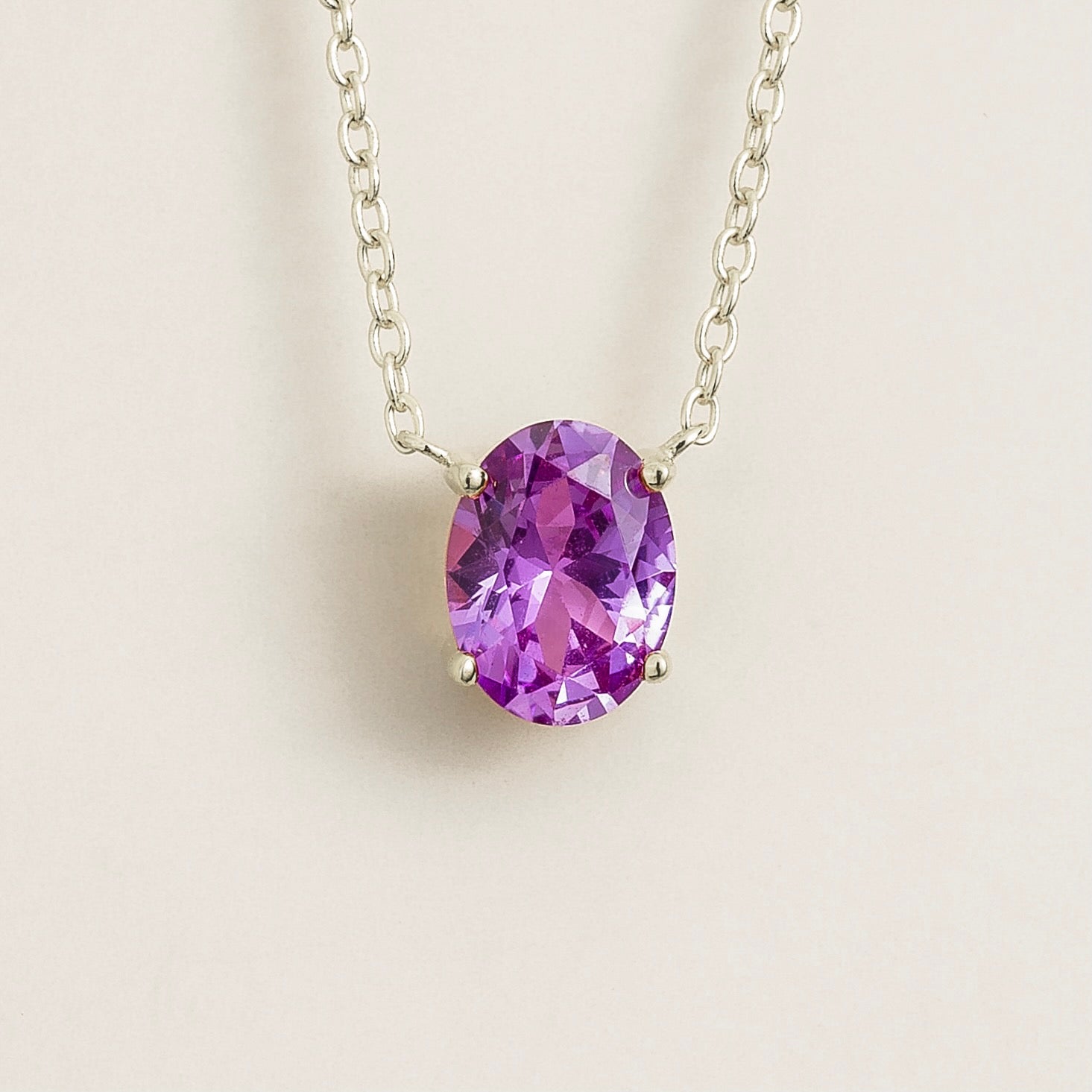 Juvetti white gold necklace featuring an oval lab-grown purple sapphire solitaire pendant.