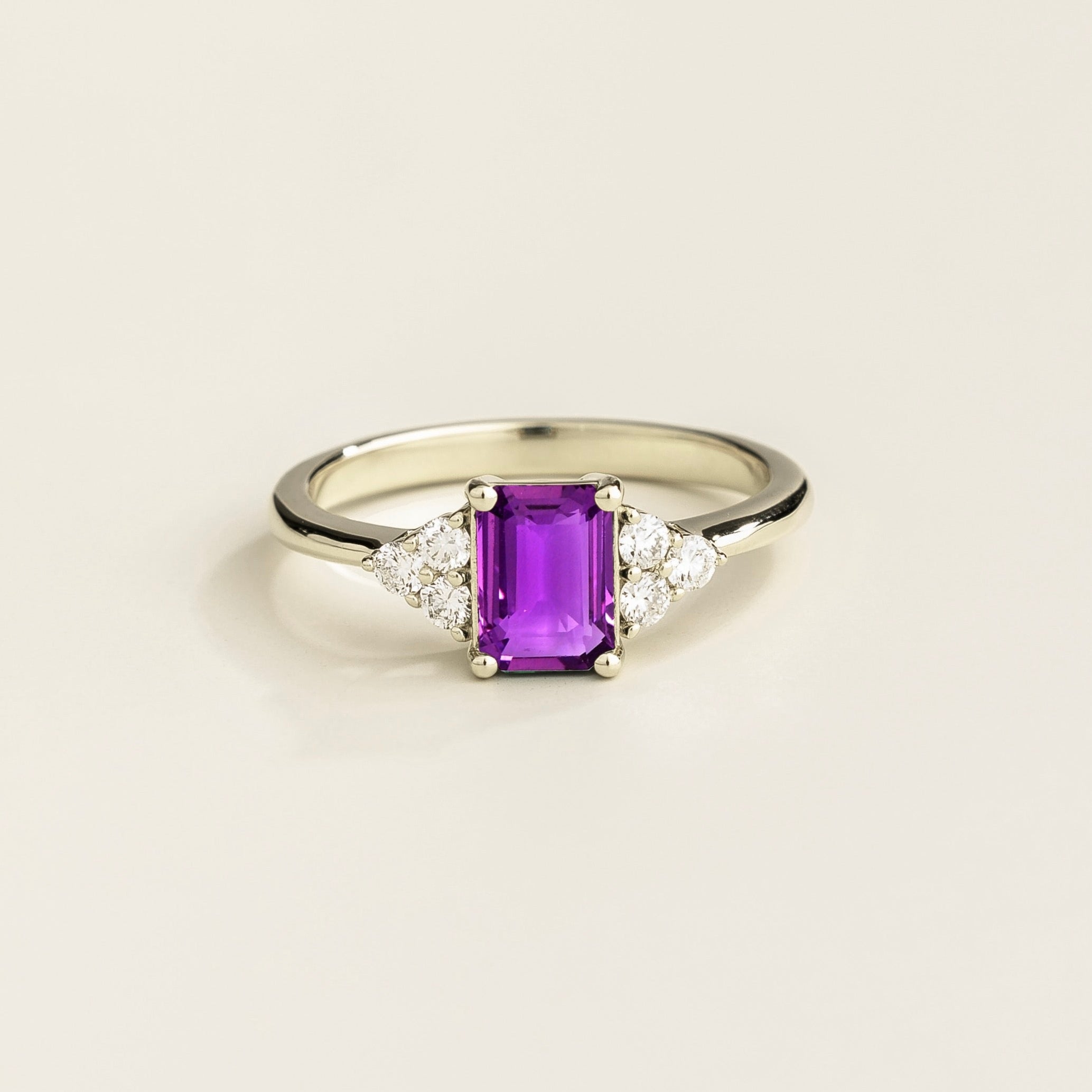 Juvetti white gold ring featuring an emerald-cut lab-grown purple sapphire with lab-grown diamond side stones.