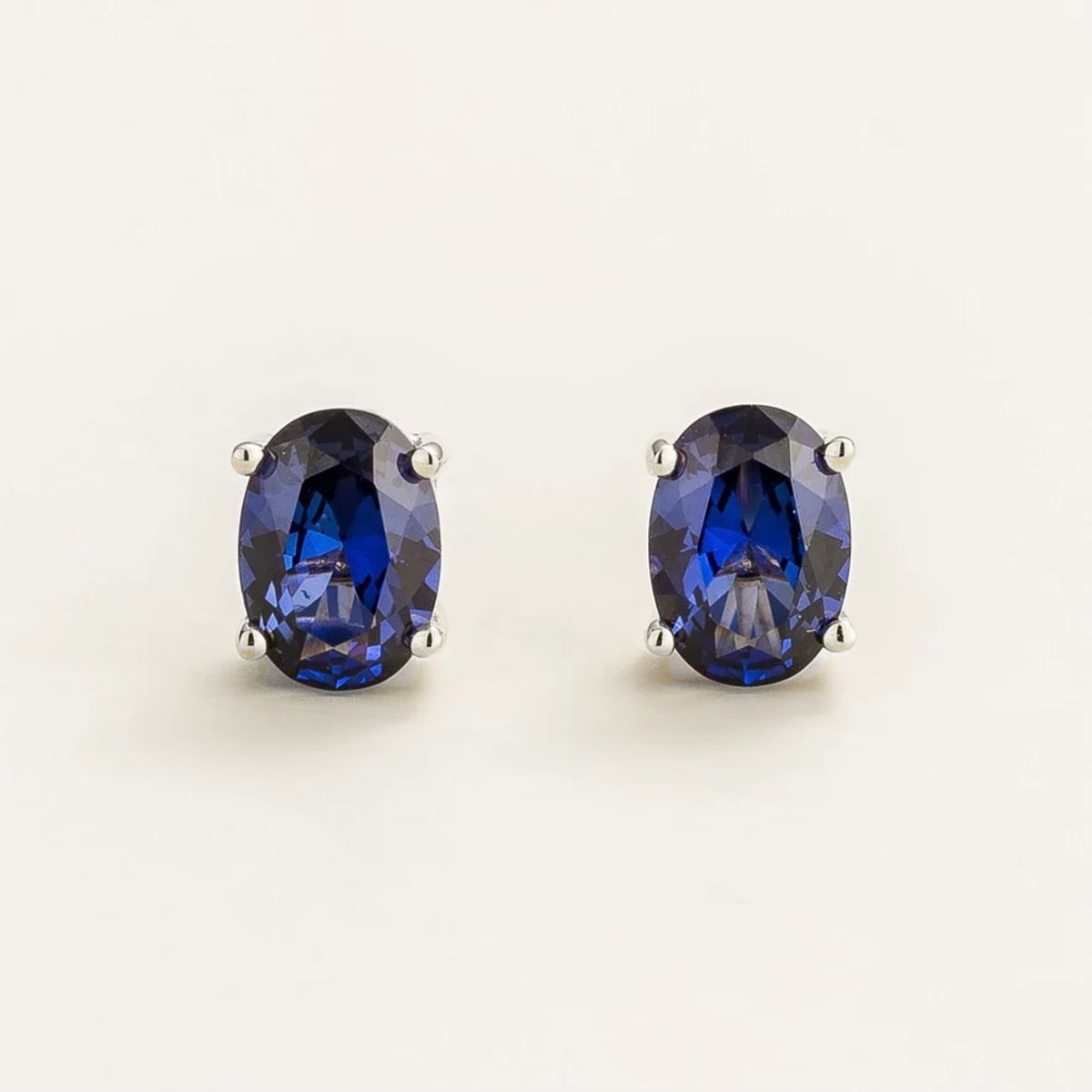 Ovo blue sapphire oval solitaire stud earrings in white gold