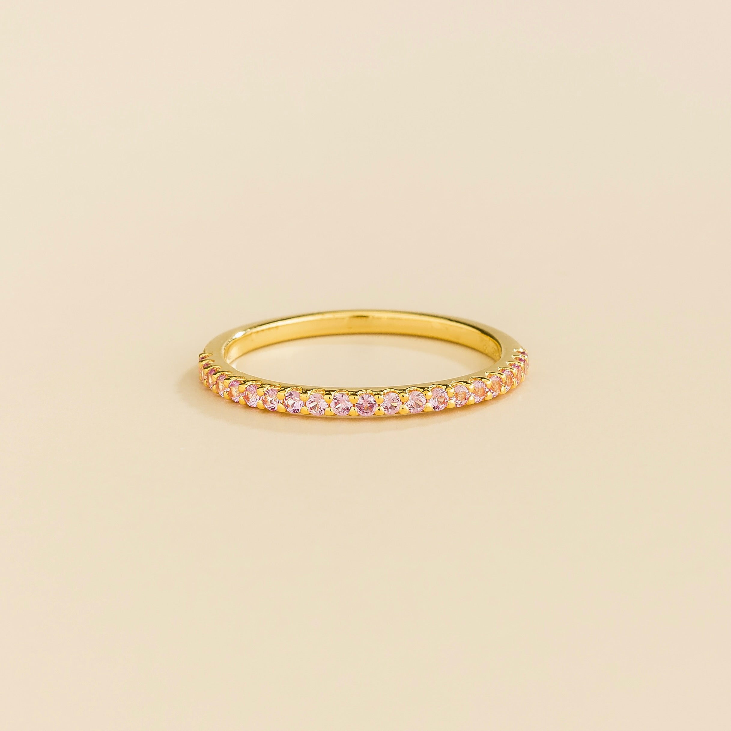 Juvetti yellow gold half eternity band set with round lab-grown pink sapphires.