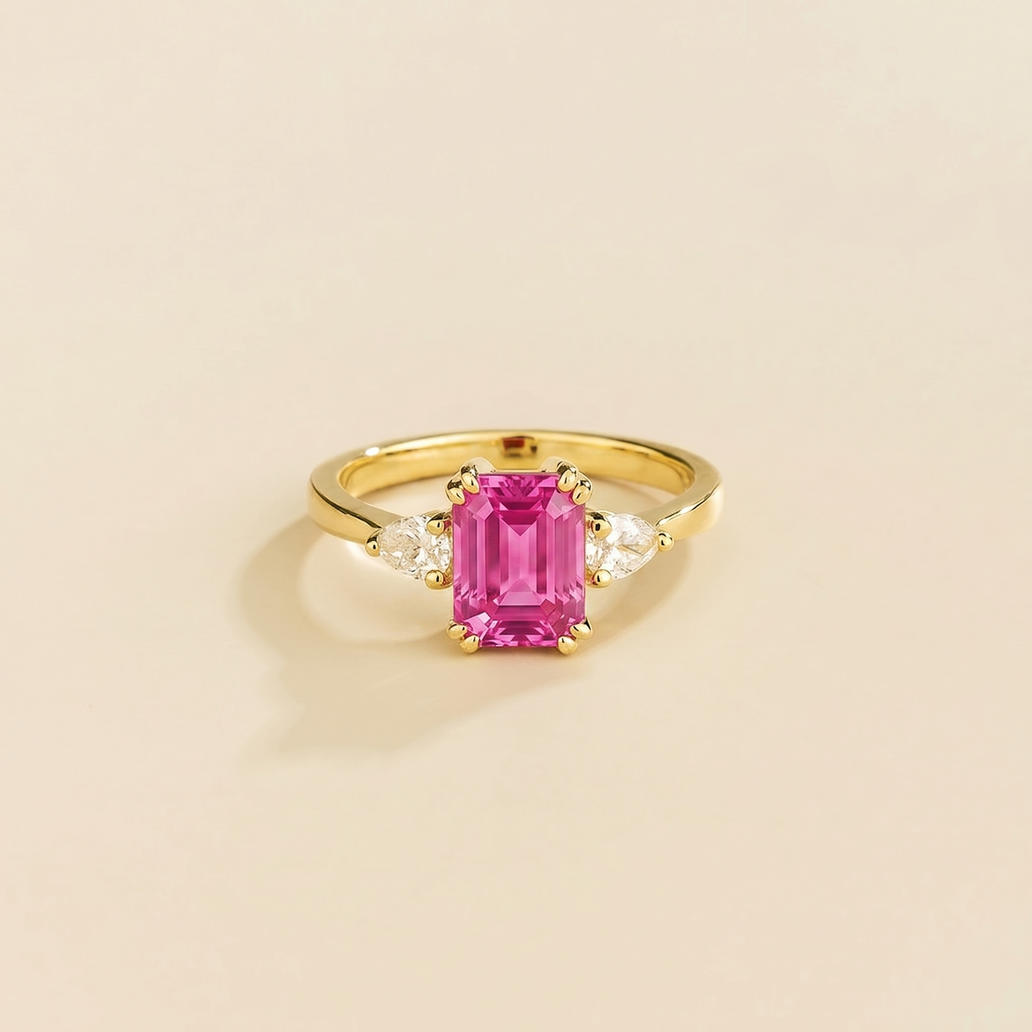 Emerald-cut lab-grown pink sapphire ring with pear-cut diamond sides, Ailes design in gold | Juvetti London