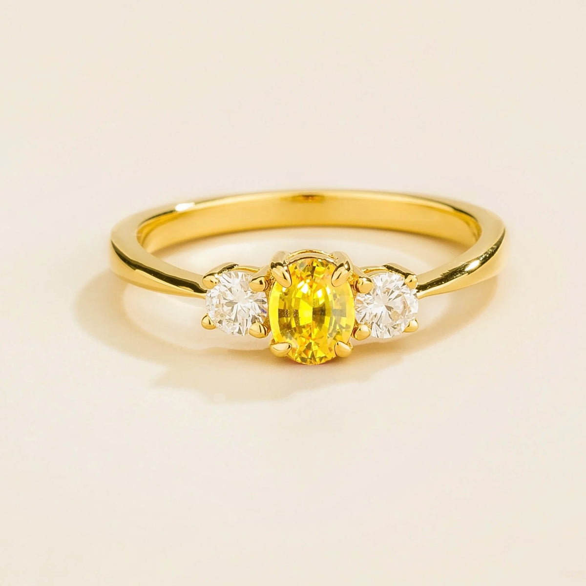 3 gemstone yellow gold ring featuring a central yellow sapphire with two smaller diamonds on each side