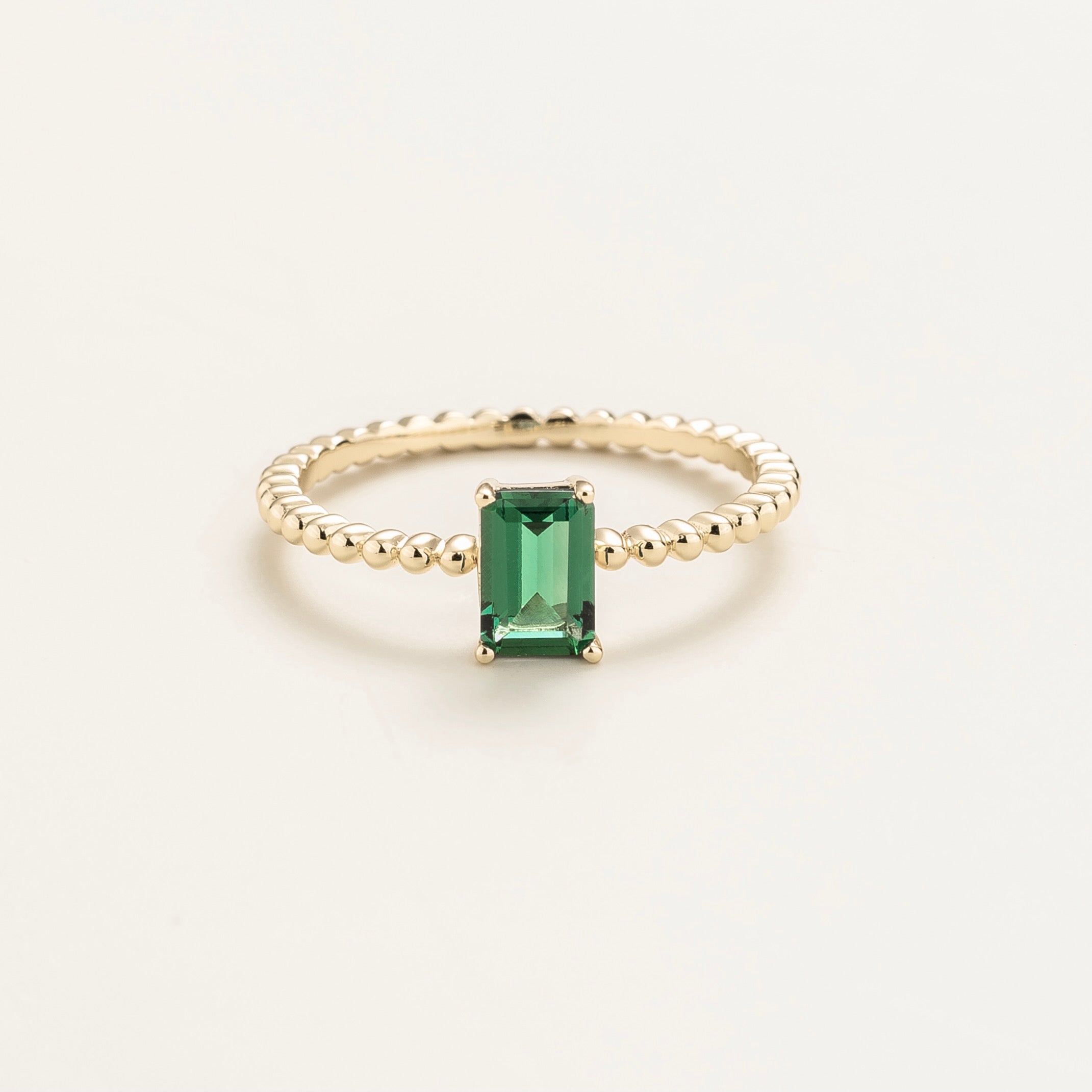 Juvetti white gold ring featuring an emerald-cut lab-grown emerald on a beaded band.