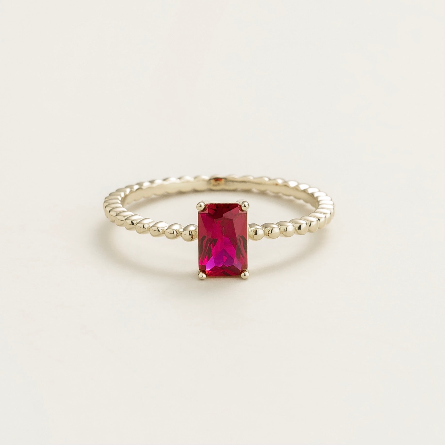 Juvetti white gold ring featuring an emerald-cut lab-grown ruby on a beaded band.
