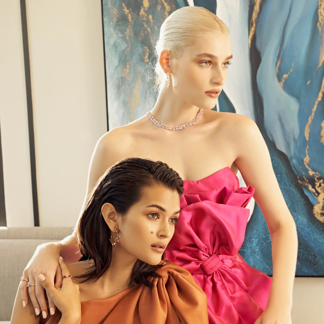 Models wearing pink and tan night dress. One is wearing lab grown pink sapphire and diamond as Lago Rosa necklace, Lanna earrings and Diana rings. Another is wearing lab grown diamond and ruby on Forma ring and Lanna earrings.
