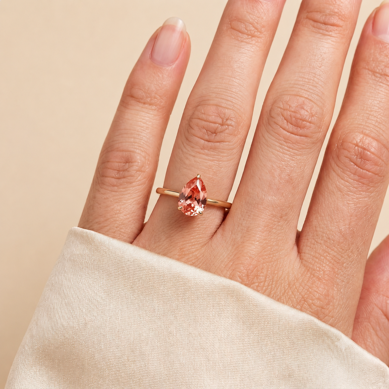 A model is wearing Pandal Pear Shape Padparadscha Sapphire Cathedral Solitaire Ring