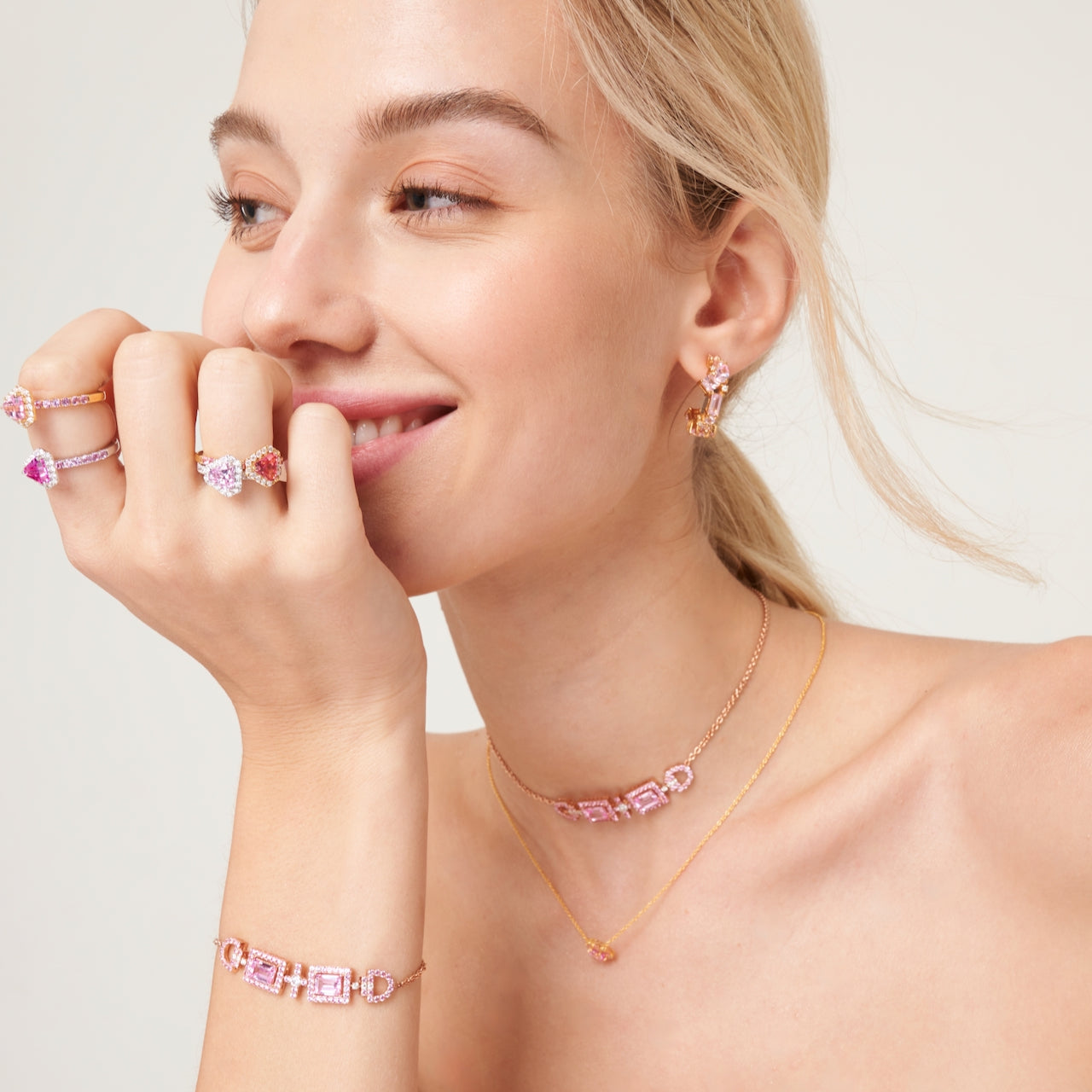 A model wearing Diana rings, Ciceris necklace and bracelet, Melba earrings and Lanna earrings set with lab grown diamond, pink sapphire and padparadscha gem stone