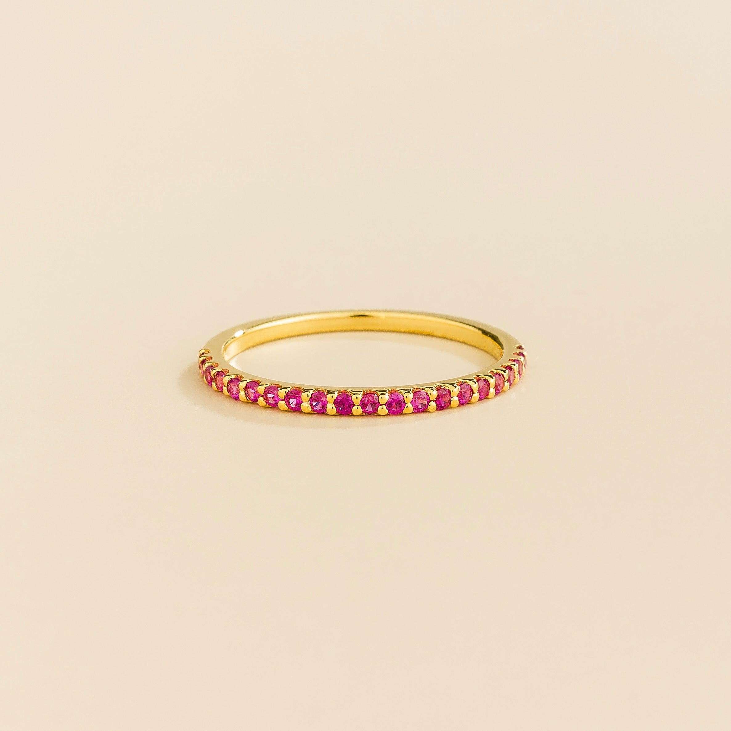 Juvetti yellow gold half eternity band set with round lab-grown ruby gemstones.