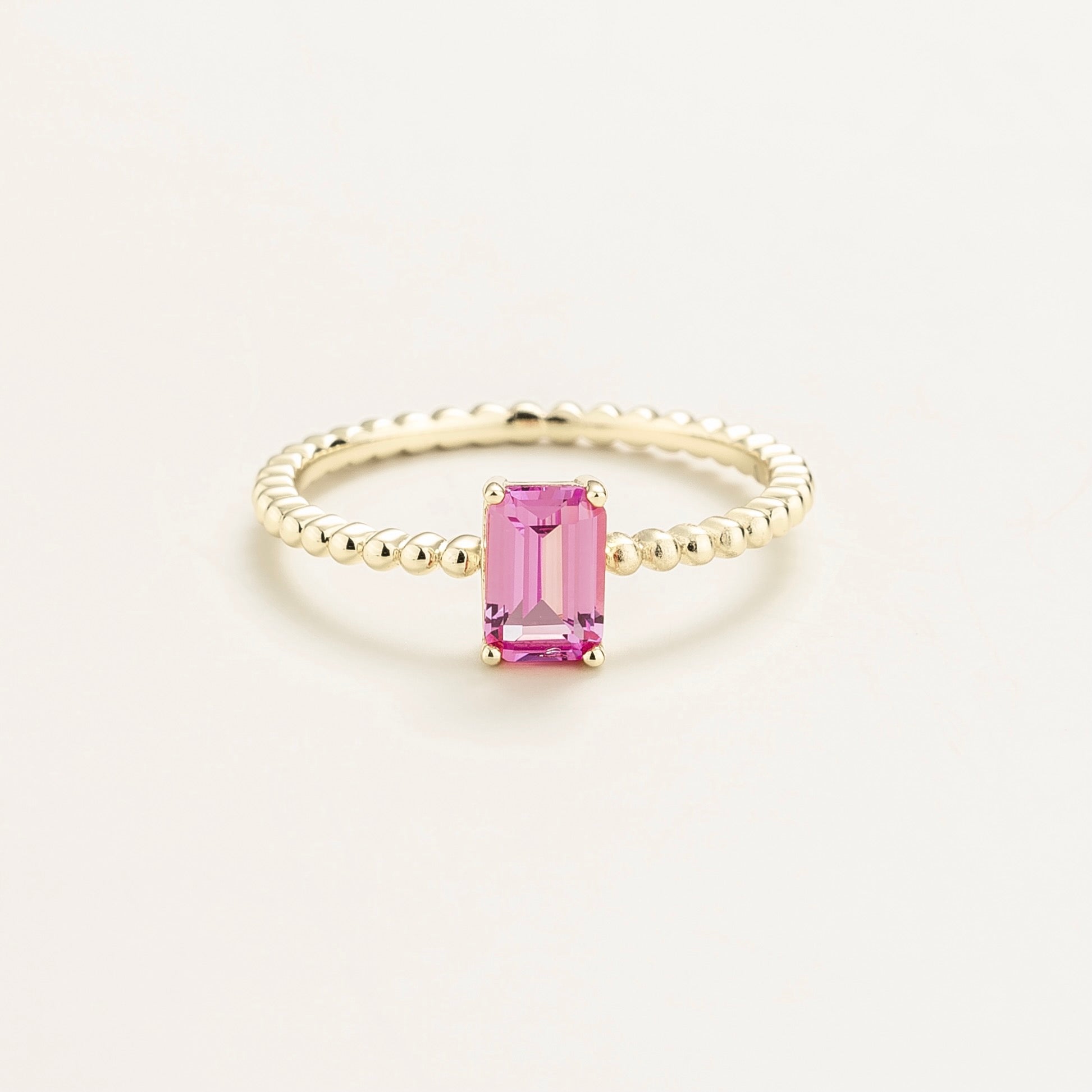 Juvetti white gold ring featuring an emerald-cut lab-grown pink sapphire on a beaded band.