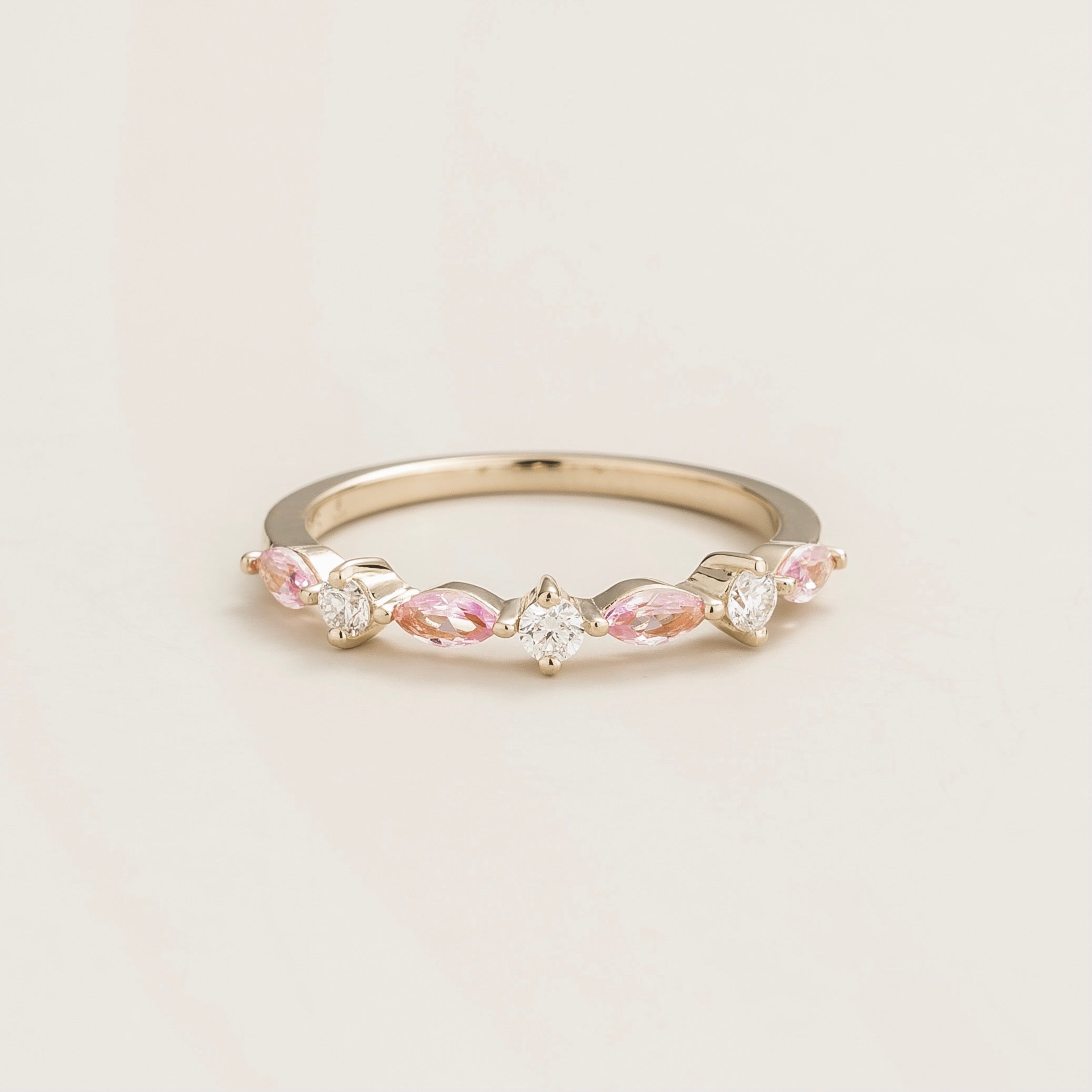 A white gold band ring set with marquis cut pink sapphires and round diamonds.