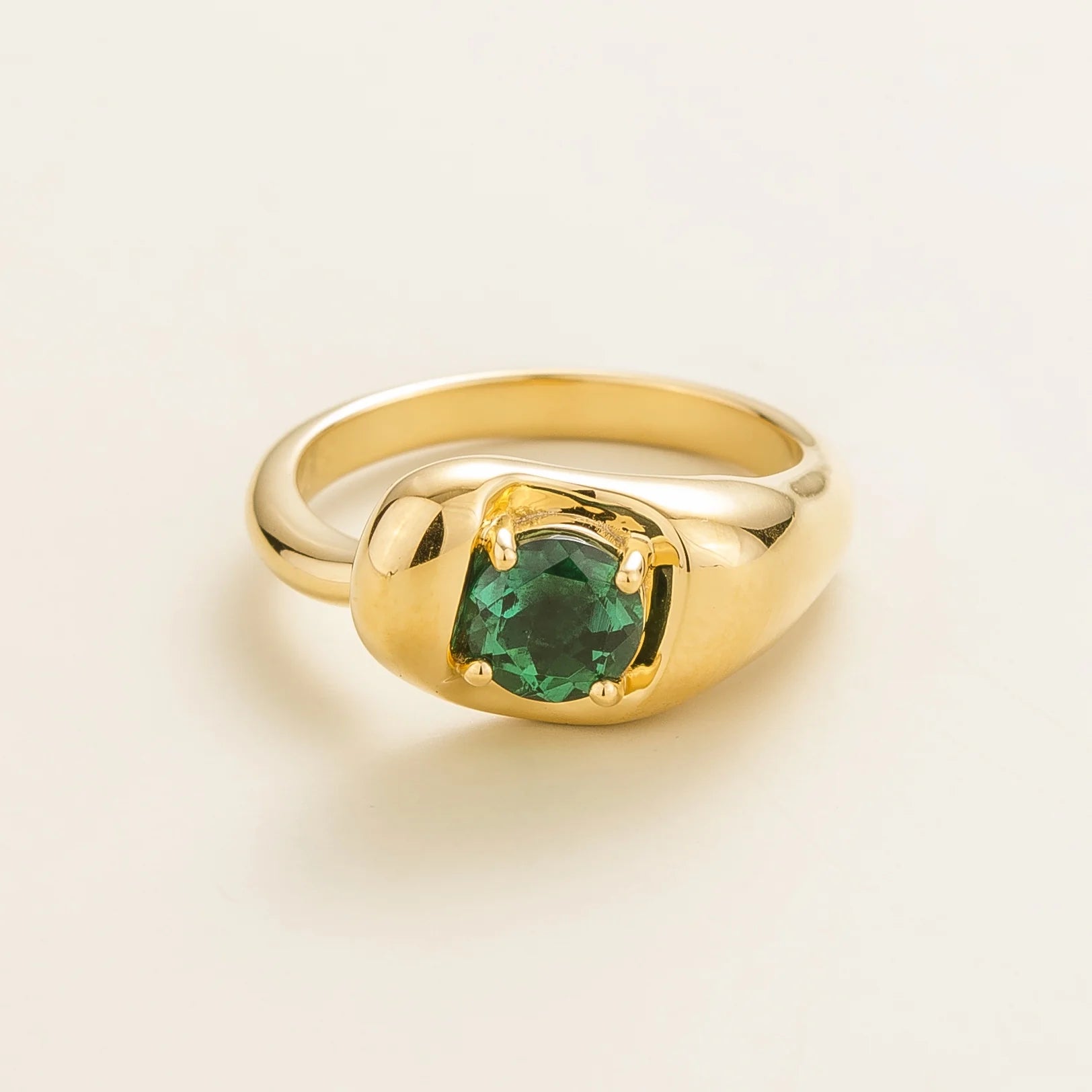 Juvetti yellow gold ring featuring a round lab-grown emerald in a bold contemporary setting.
