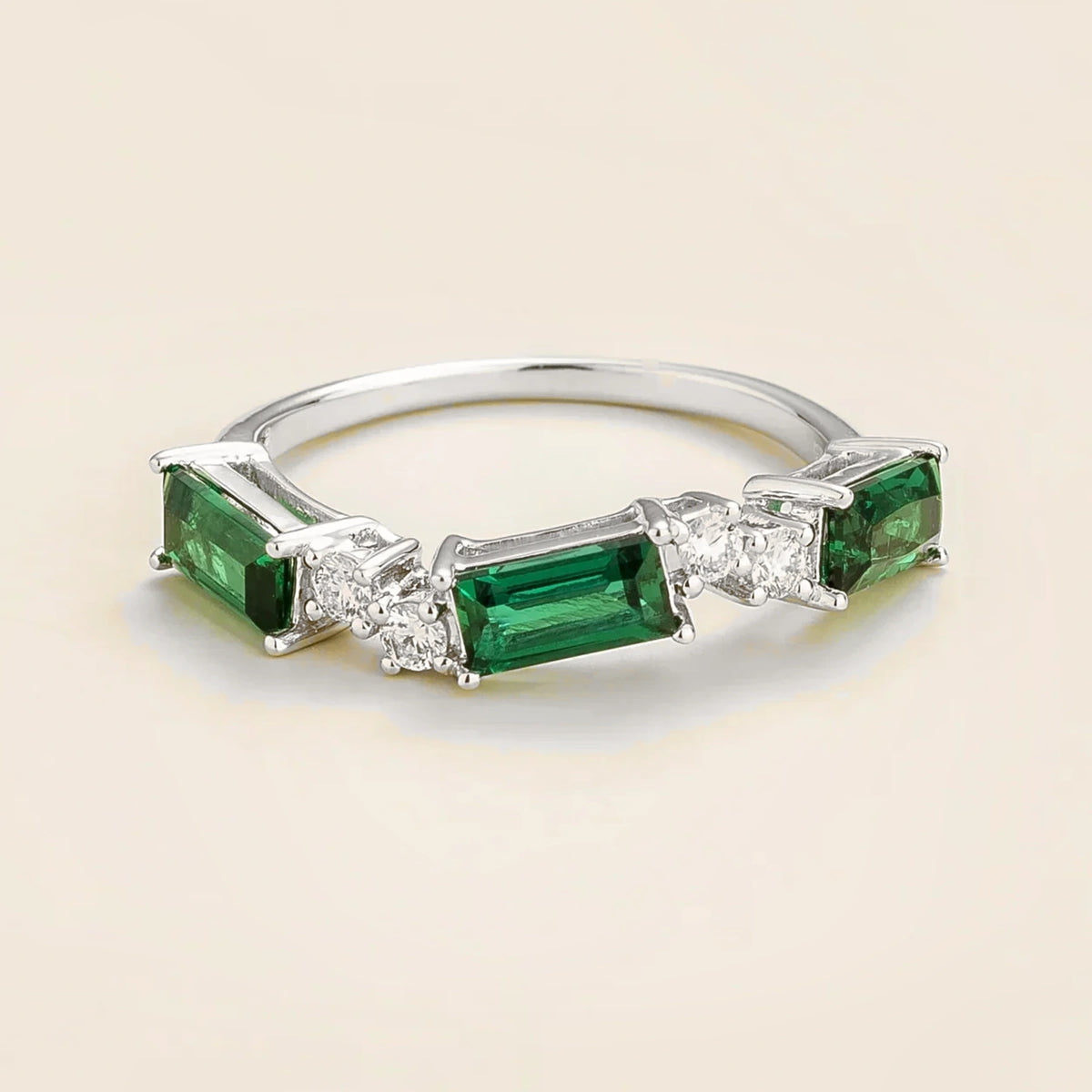 Juvetti white gold ring showcasing ethical lab-grown baguette-cut emeralds and round brilliant diamonds.