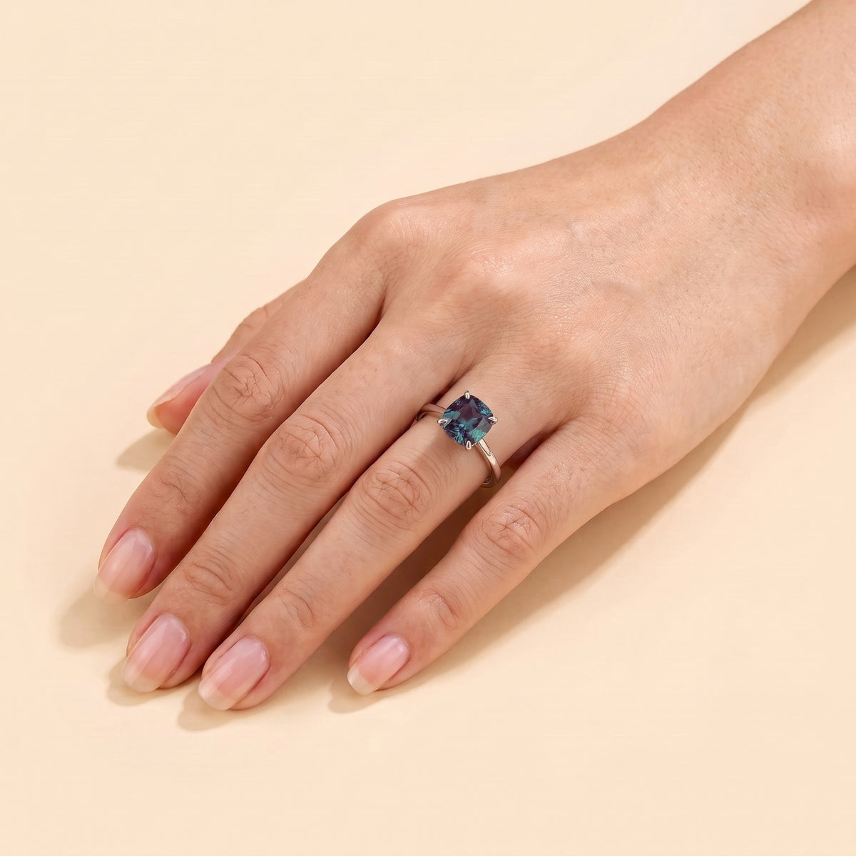 A model is wearing Iris Cushion Shape Alexandrite Cathedral Solitaire