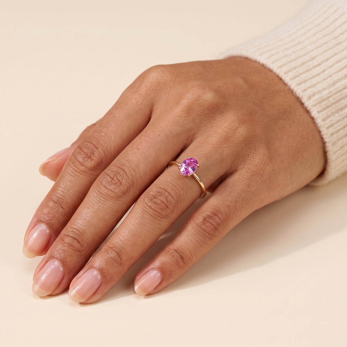A model is wearing Lyra Oval Shape Vivid Pink Sapphire Cathedral Solitaire Ring in Gold