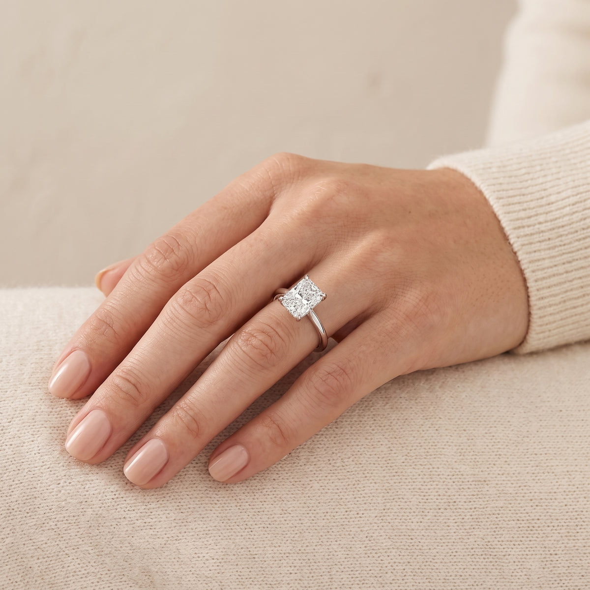 A model is wearing Clair Radiant Shape Diamond Cathedral Solitaire Ring