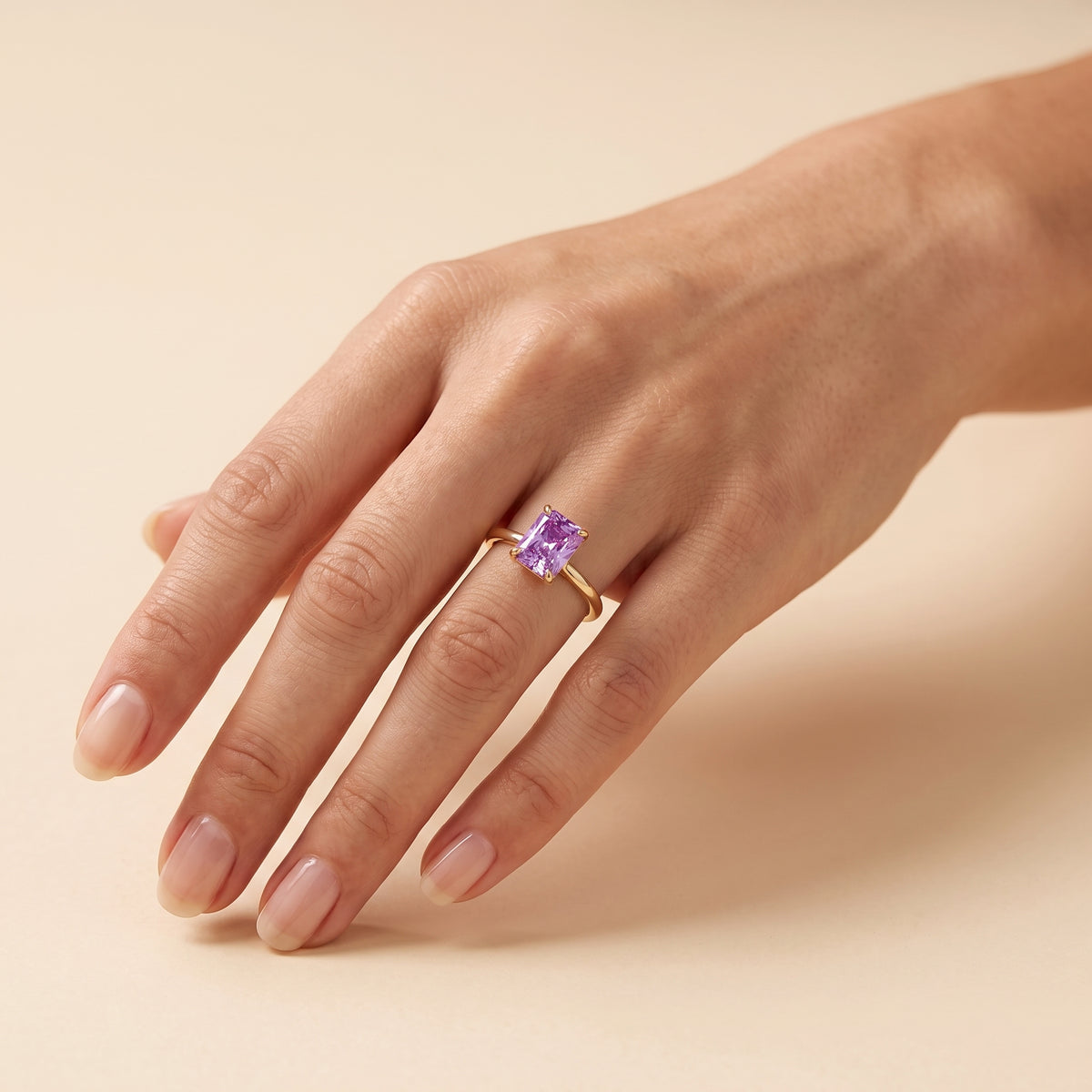 A model is wearing Clair Radiant Shape Purple Sapphire Cathedral Solitaire Ring