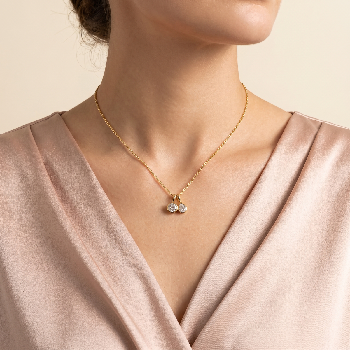Angled view of the Prunus diamond necklace in gold showing the round and pear diamond, Juvetti London