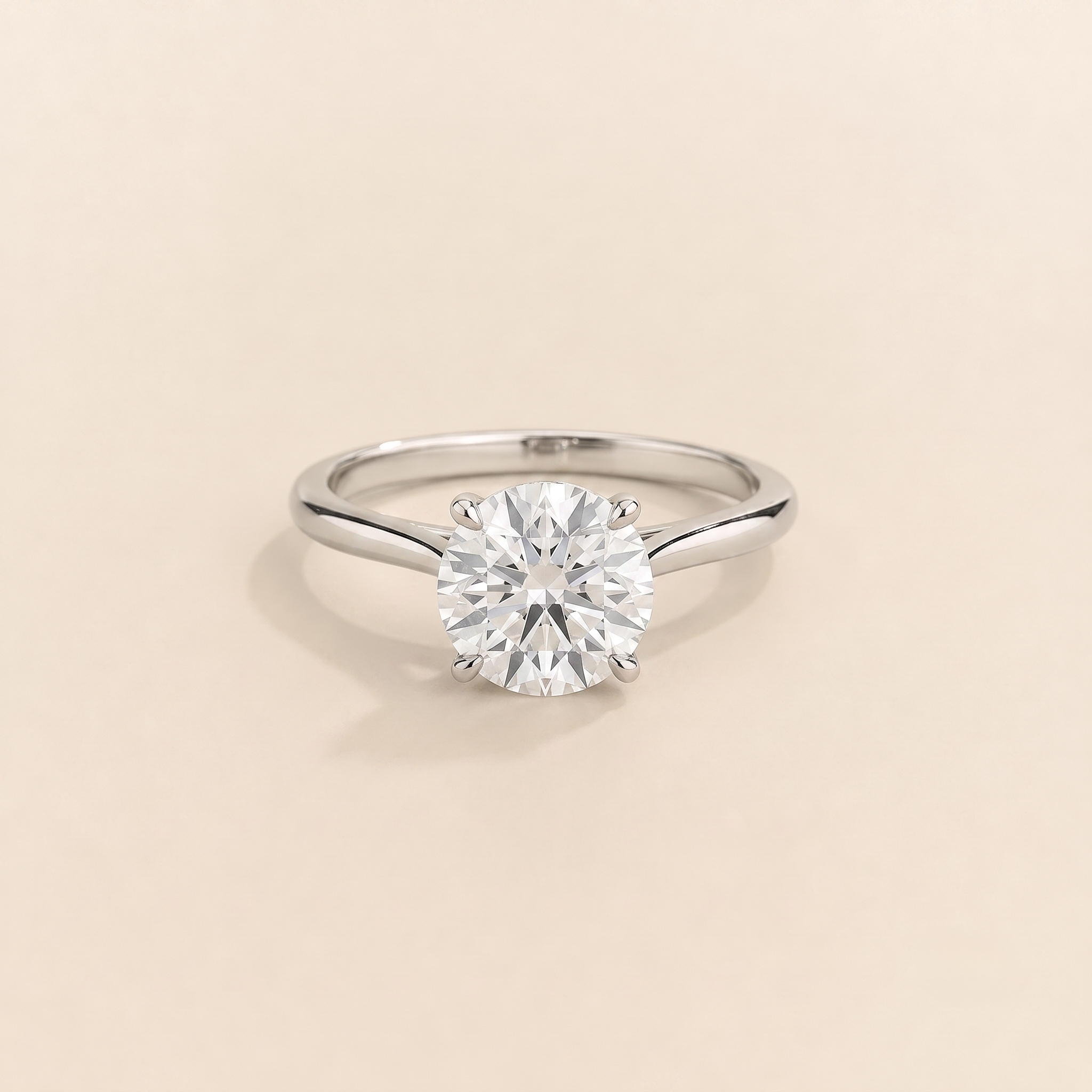 Kissen Ring in white gold, set with a round cut Diamond in an east–west setting.