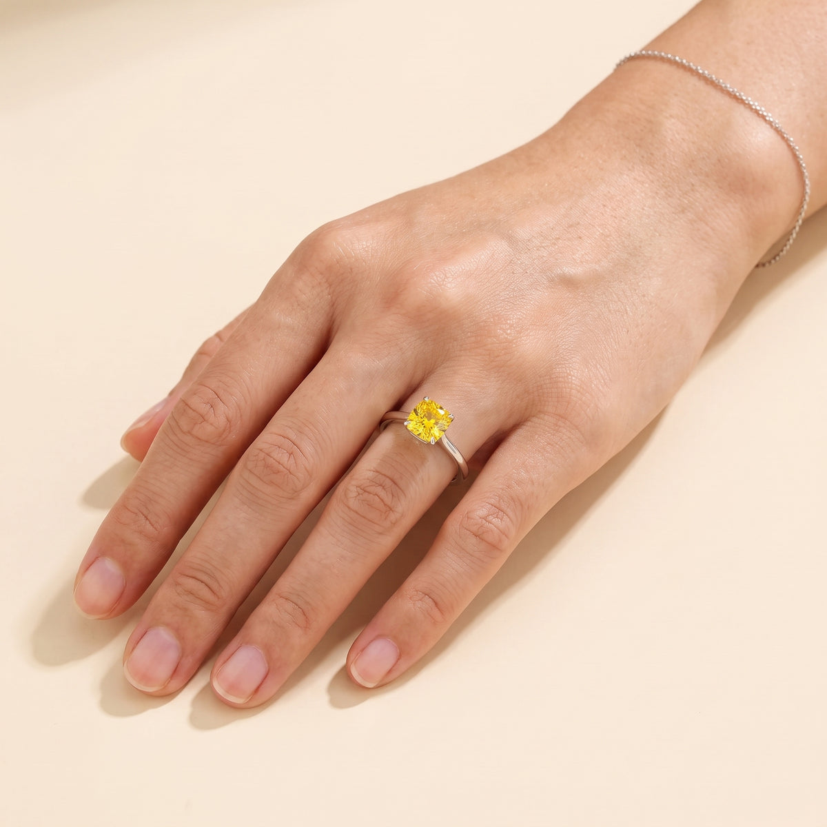 A model is wearing Iris Cushion Shape Yellow Sapphire Cathedral Solitaire