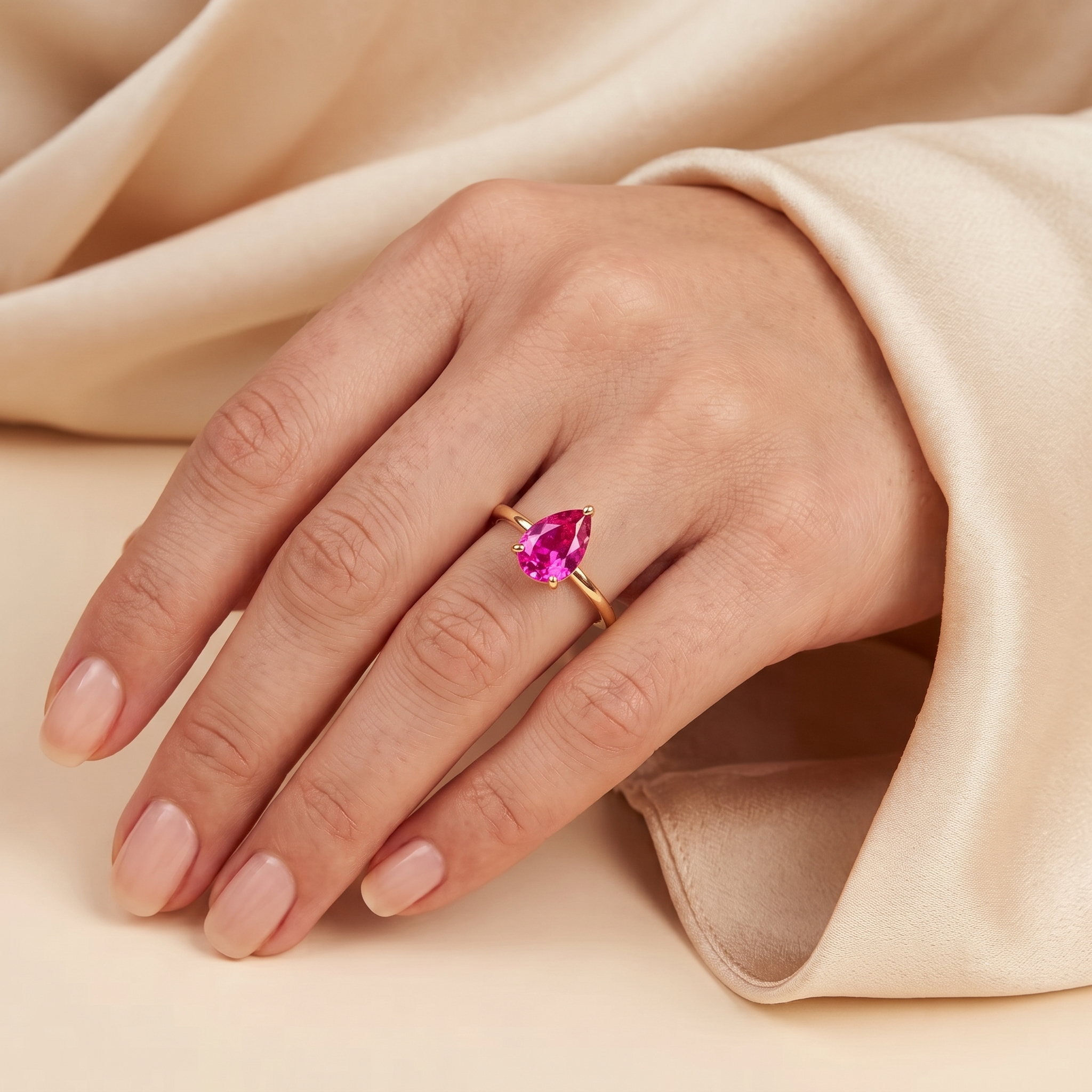 A model is wearing Pandal Pear Shape Vivid Pink Sapphire Cathedral Solitaire