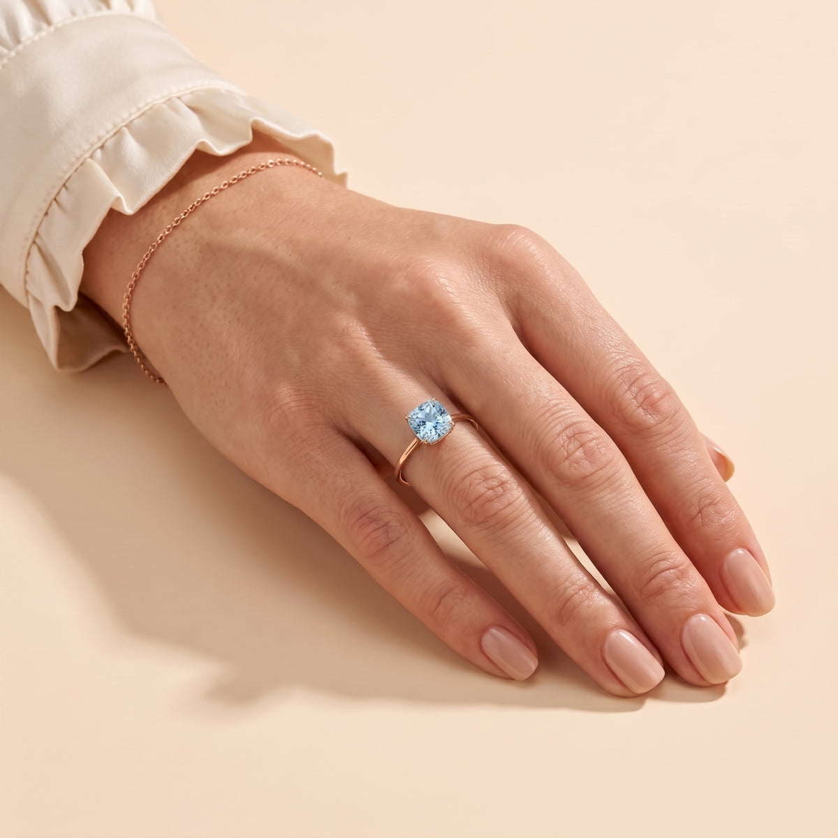 A model is wearing Iris Cushion Shape Aquamarine Cathedral Solitaire