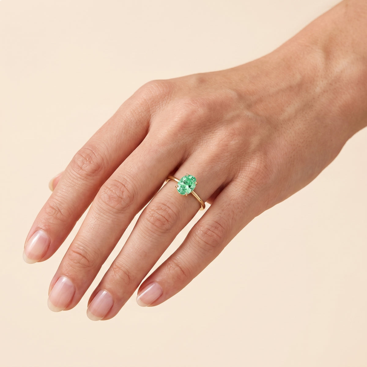 The model is wearing Lyra Oval Shape Green Sapphire Cathedral Solitaire Ring in Gold
