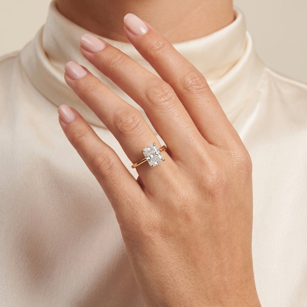 A model is wearing Clair Radiant Shape Diamond Cathedral Solitaire Ring