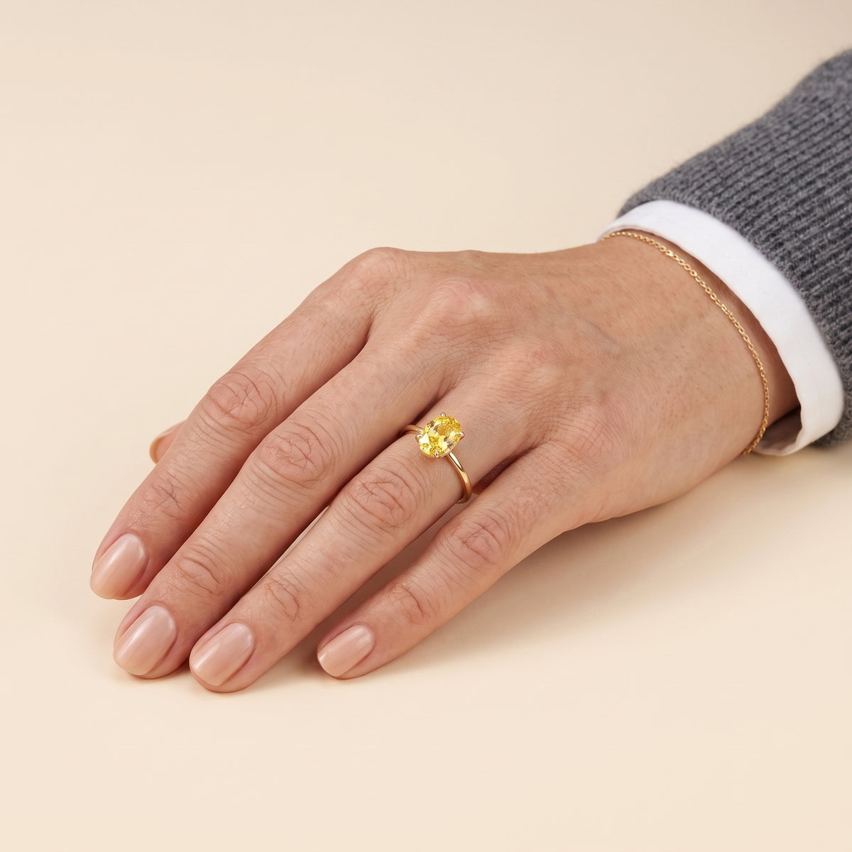 A model is wearing Lyra Oval Shape Yellow Sapphire Cathedral Solitaire Ring in Gold
