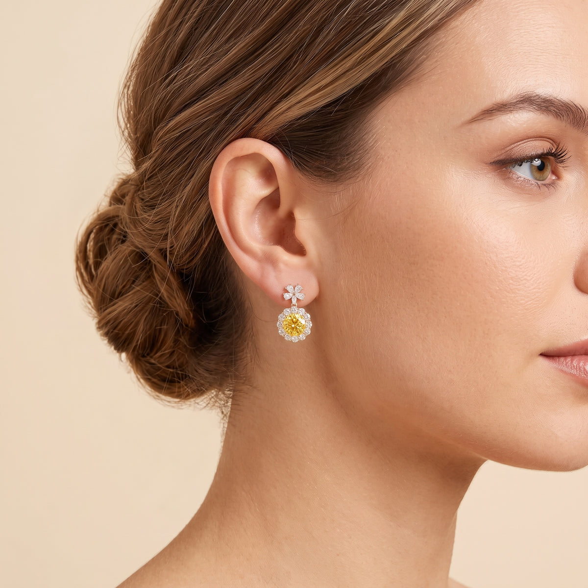 A model is wearing The Antoinette Round Yellow Sapphire & Diamond Halo Pendant Earrings with Flower Bail