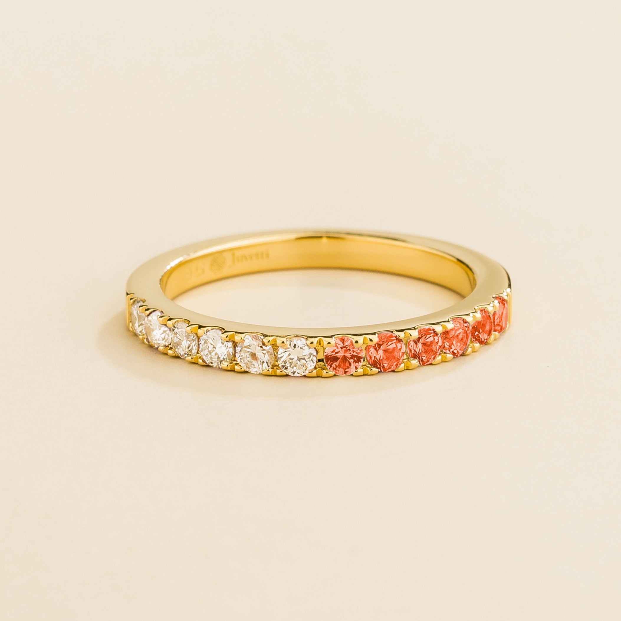 Juvetti yellow gold band featuring round lab-grown diamonds and padparadscha sapphires set in a half-eternity design.
