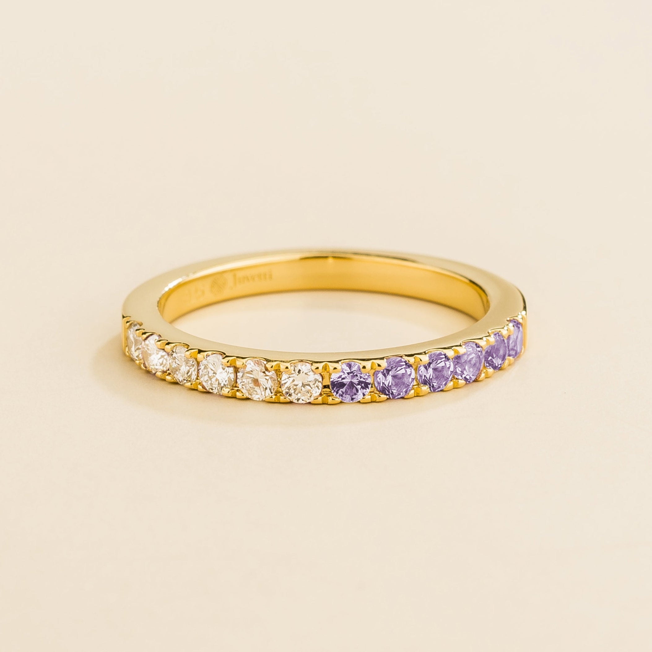 Juvetti yellow gold band featuring round lab-grown diamonds and purple sapphires set in a half-eternity design.