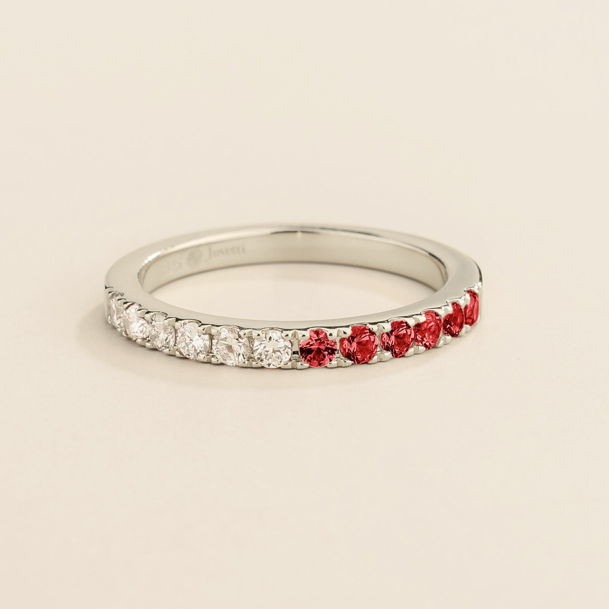 Juvetti white gold band featuring round lab-grown diamonds and ruby set in a half-eternity design.