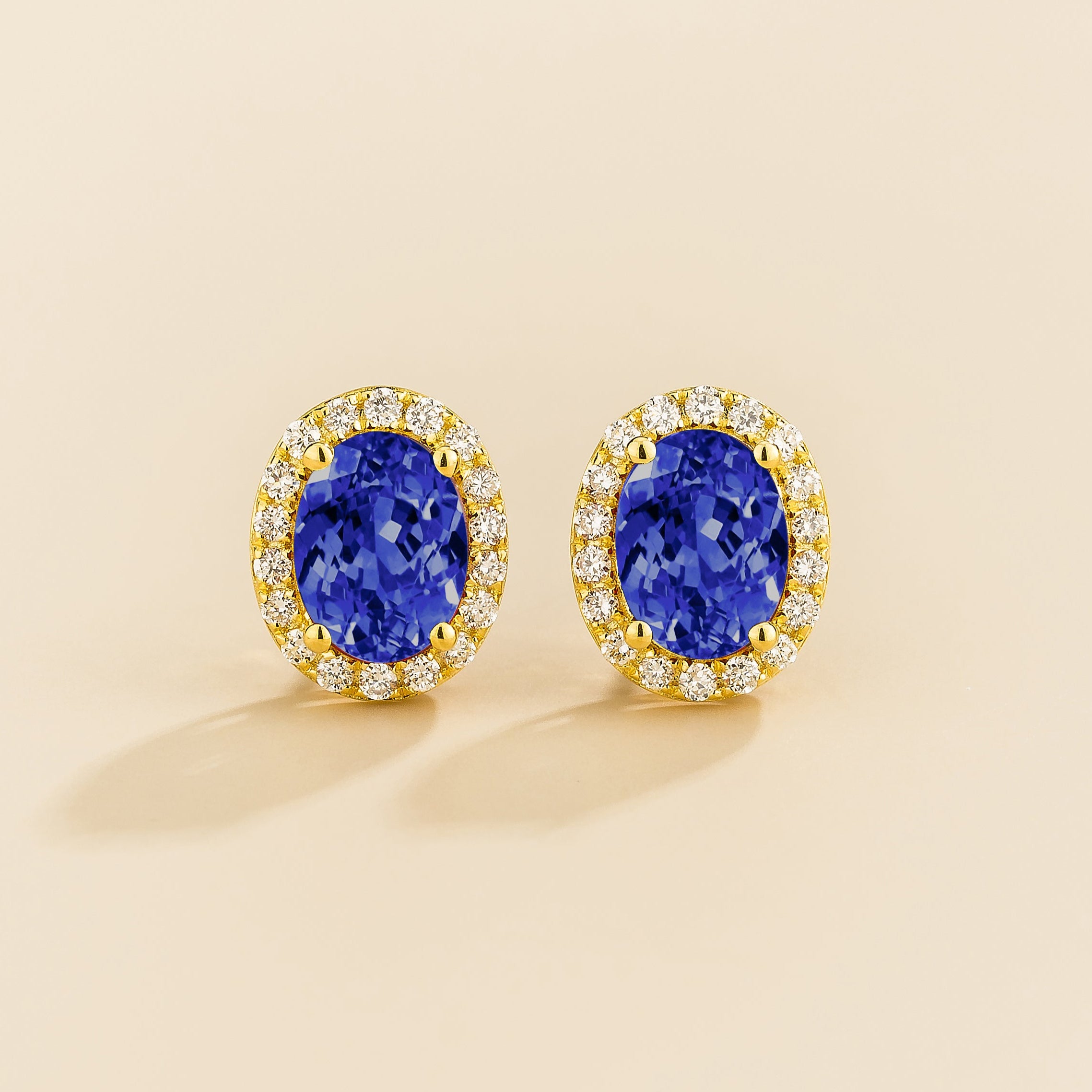 Mina gold earrings in oval shape Blue Sapphire and round diamonds halo.