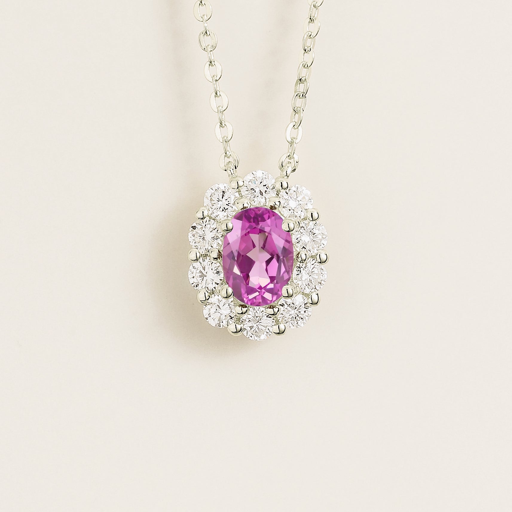 Oval pink sapphire gemstone necklace with diamond halo on white gold chain. Juvetti London Jewellery