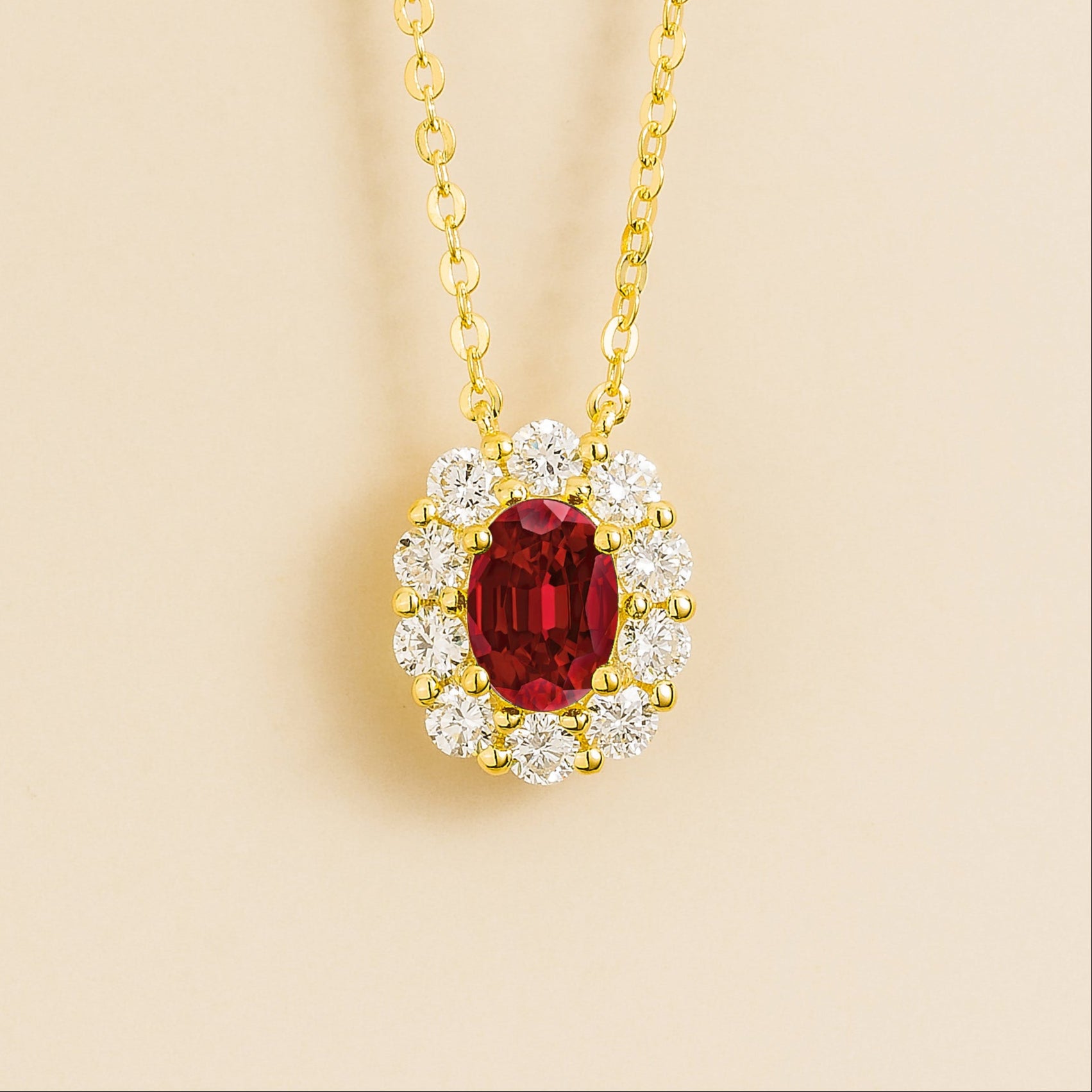 Prill necklace in gold set with oval ruby and round halo diamonds. London jewellery store