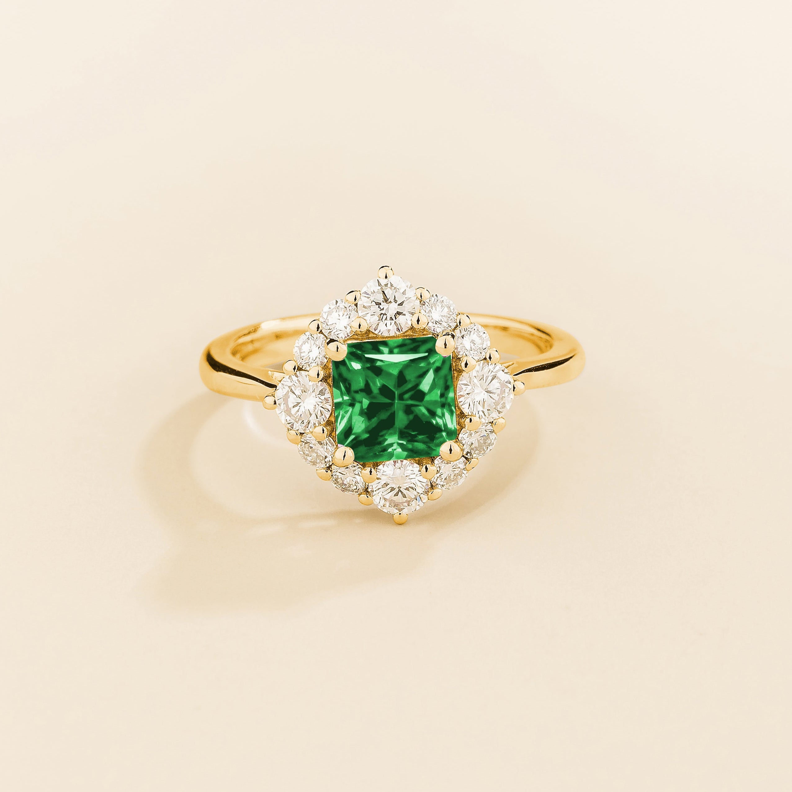 Juvetti gold ring featuring an octagon-cut lab-grown emerald surrounded by round brilliant lab-grown diamonds in a halo design.