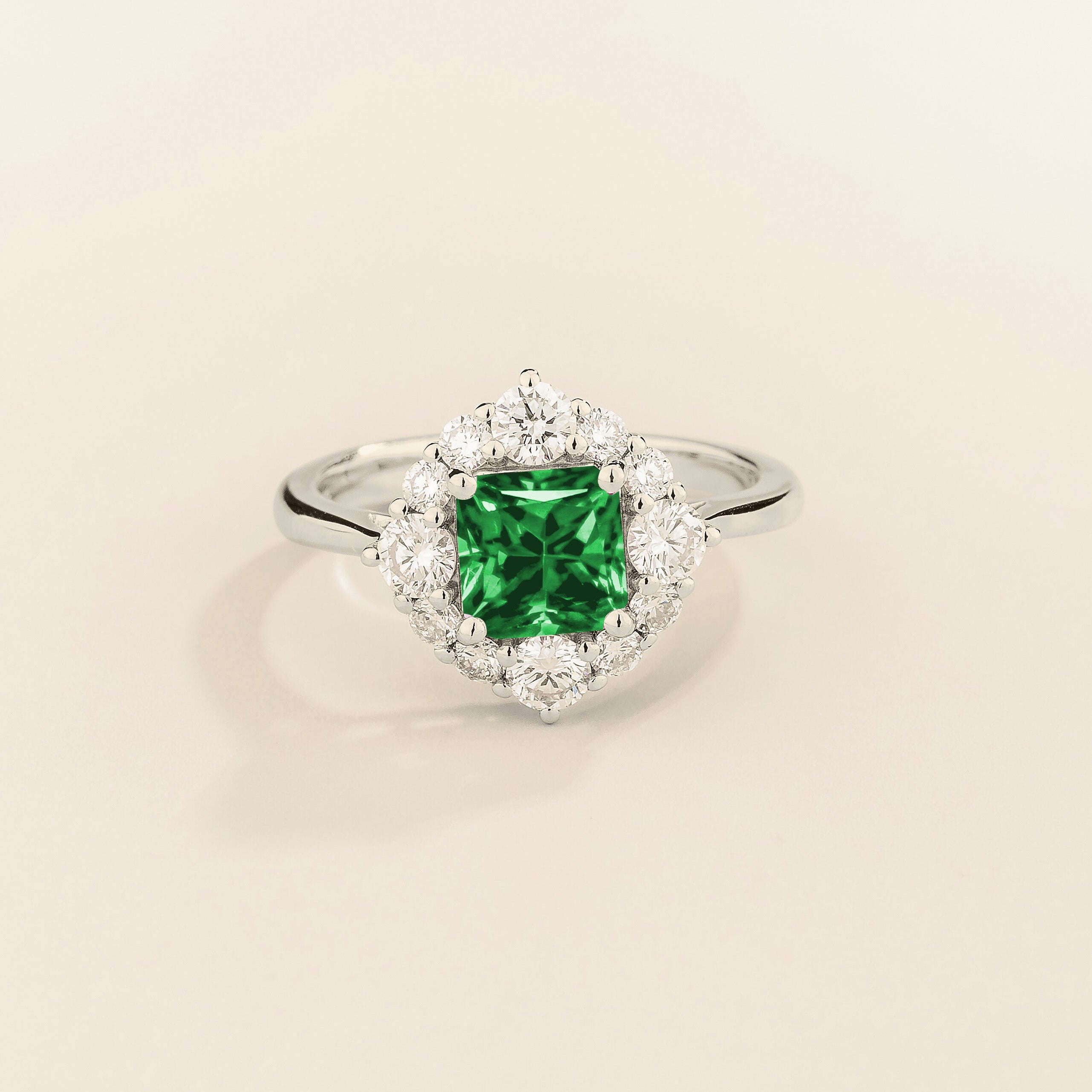Juvetti white gold ring featuring an octagon-cut lab-grown emerald surrounded by round brilliant lab-grown diamonds in a halo design.