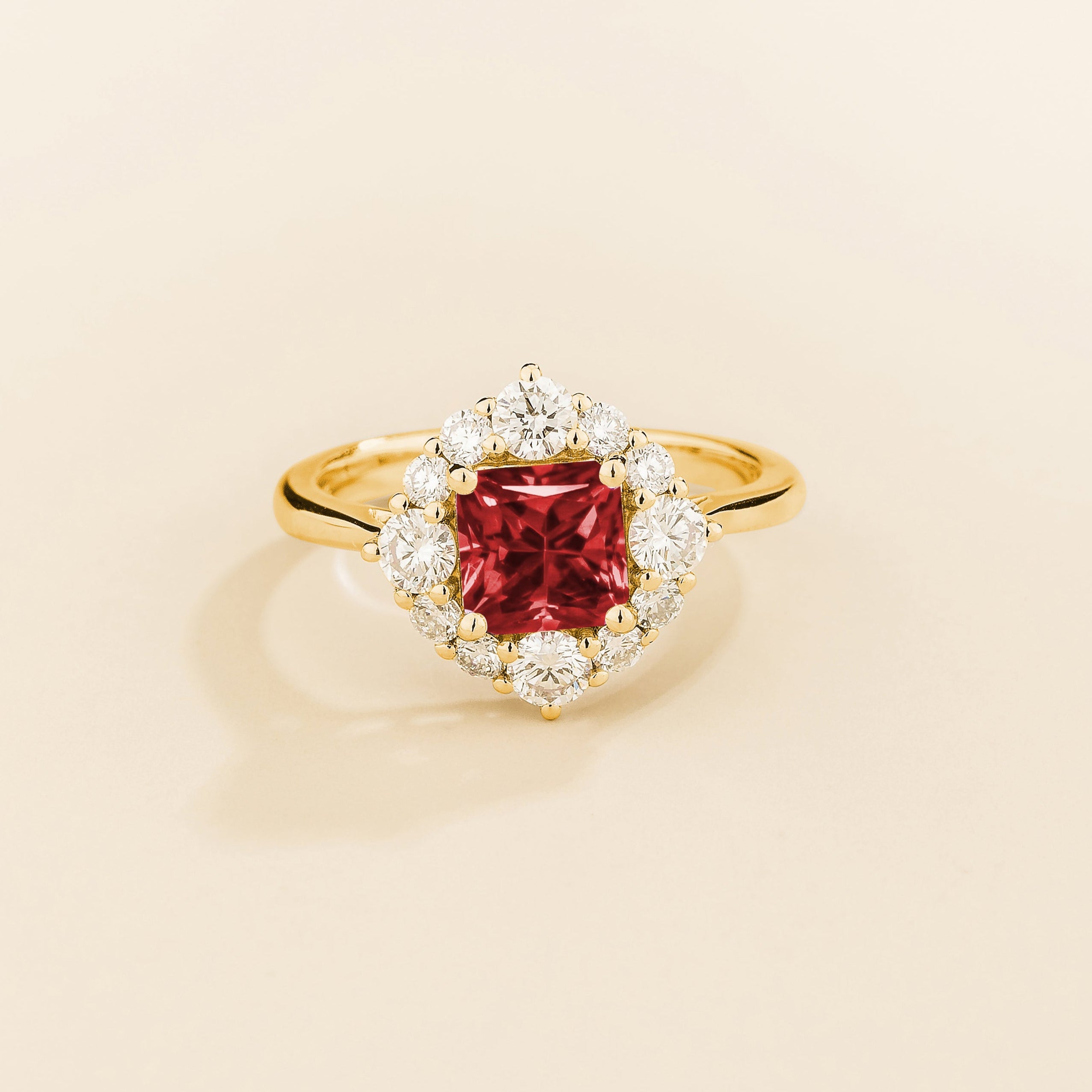 Juvetti gold ring featuring an octagon-cut lab-grown ruby surrounded by round brilliant lab-grown diamonds in a halo design.
